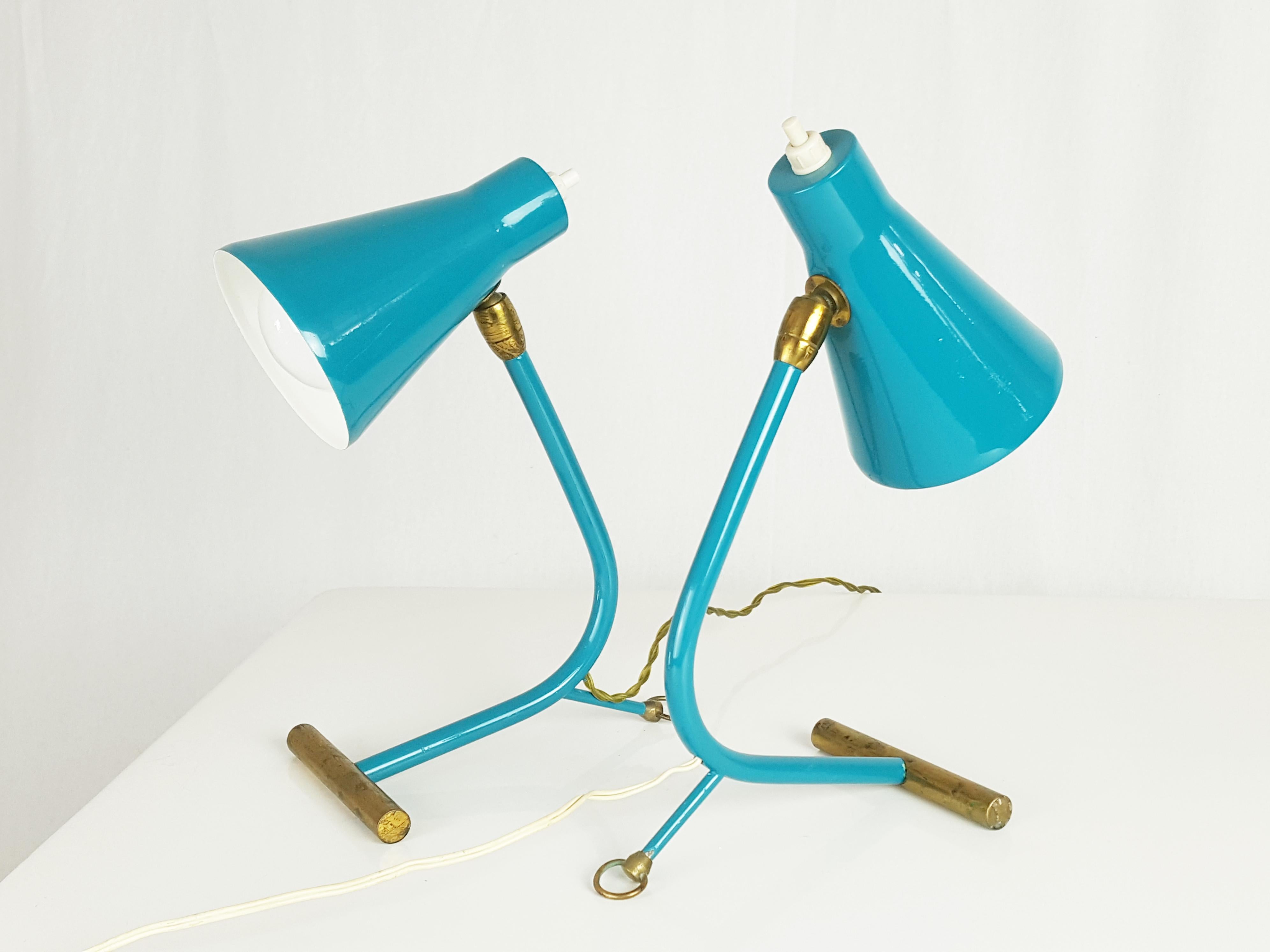 Paire de lampes de table en laiton et métal peint avec cône réglable. Grâce à un petit anneau en laiton, les lampes peuvent également être fixées au mur comme des appliques. Ils restent en bon état : quelques usures conformes à l'usage. Les lampes
