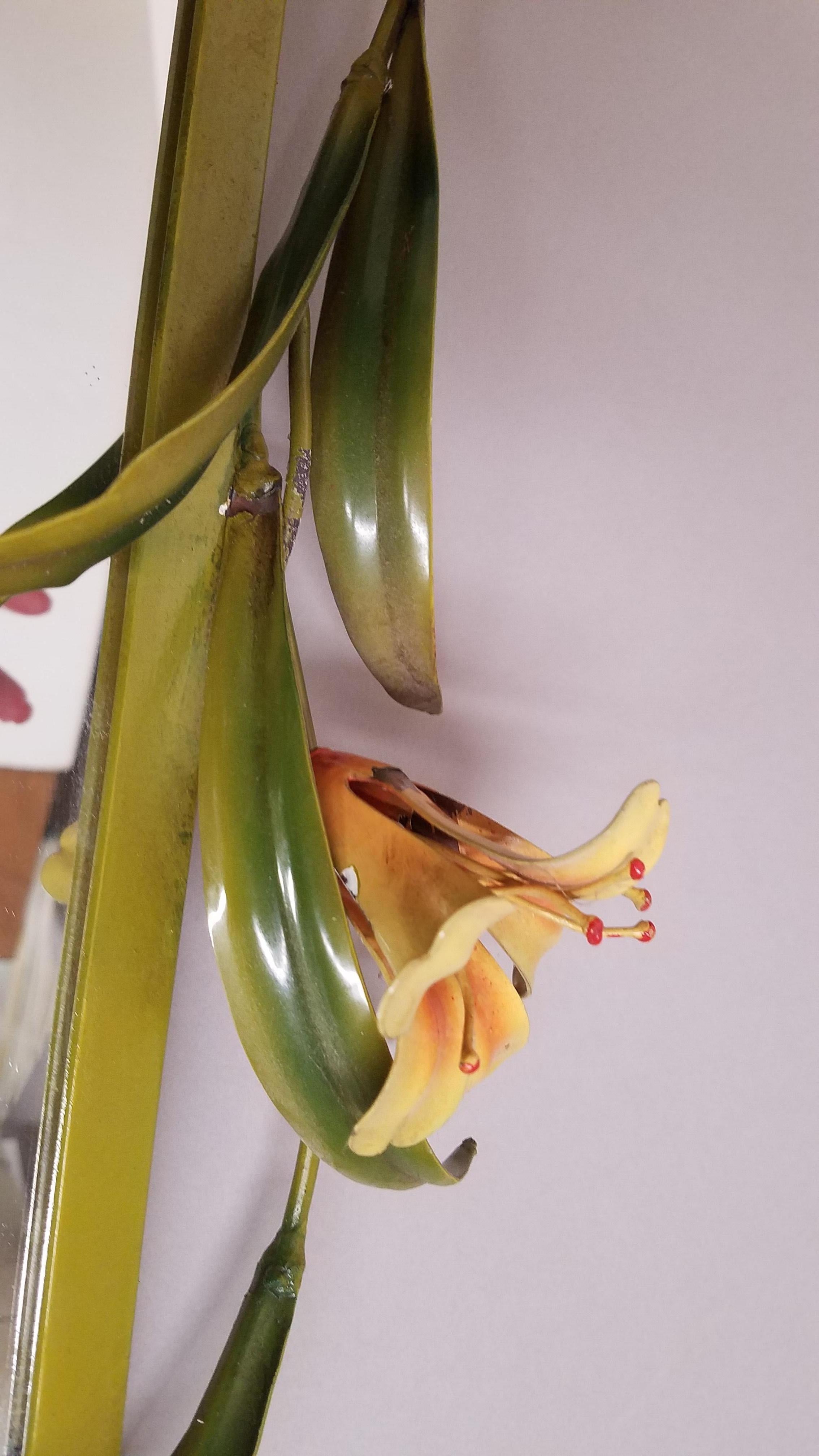 Charming old school Italian painted tole metal mirror with vibrant yellow and orange lilies with green leaves. 26 inches tall, 21 inches wide.