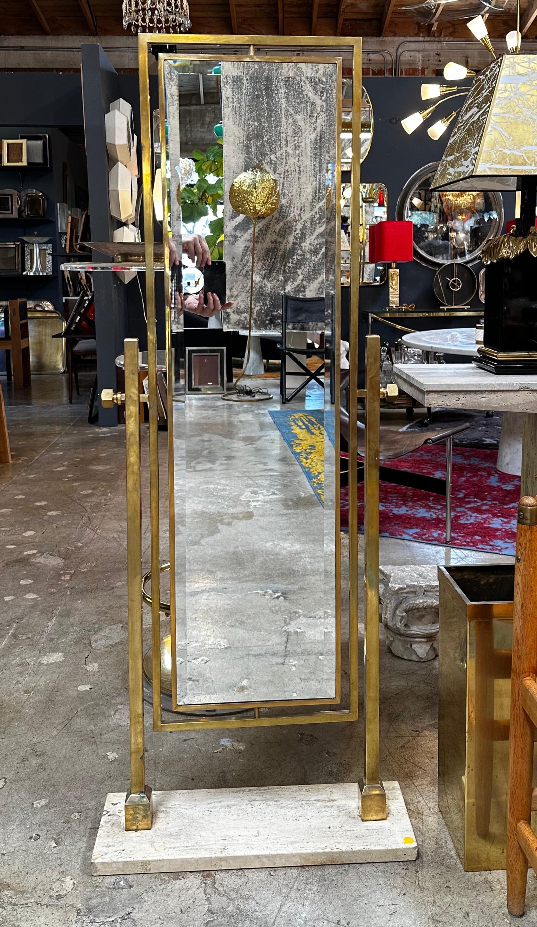 This stunning floor mirror is a vintage piece of Italian design, crafted in the 1980s. The mirror features a sleek and stylish brass frame that is adjustable, allowing you to customize the angle to your liking. The base of the mirror is made of