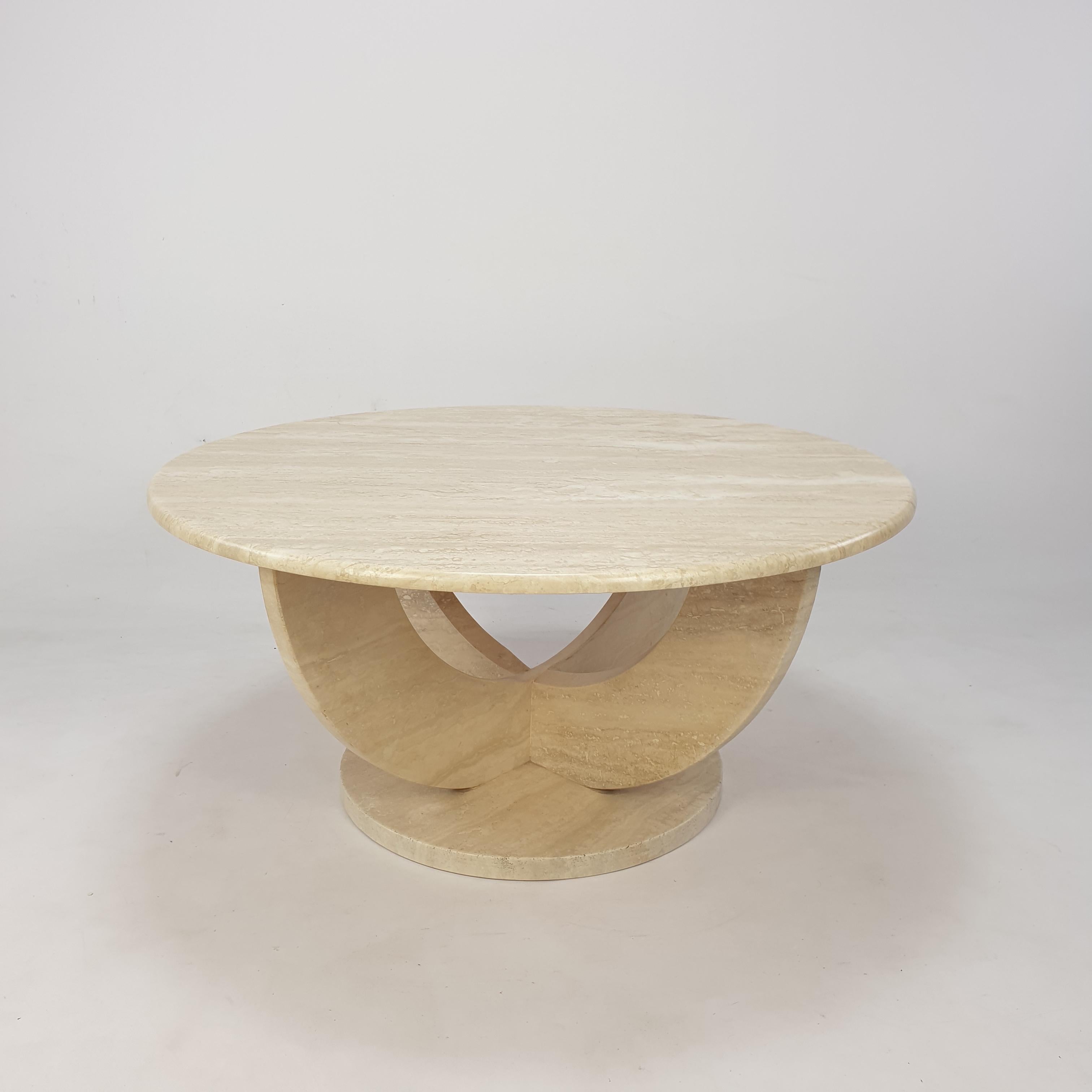 Jolie table basse italienne des années 70, fabriquée à la main en travertin. 

Une assiette ronde sur une base très élégante. 
La plaque est faite d'un très beau travertin et elle est arrondie sur le bord. 

Cette superbe table est en bon état.