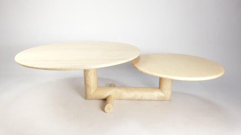Lovely travertine coffee table, fabricated in Italy in the 80's. 

Two round plates on a very elegant base. 
The plates are turnable so you can vary the with (115 to 155 cm) of the table (see the pictures). 


This rare table is made of very