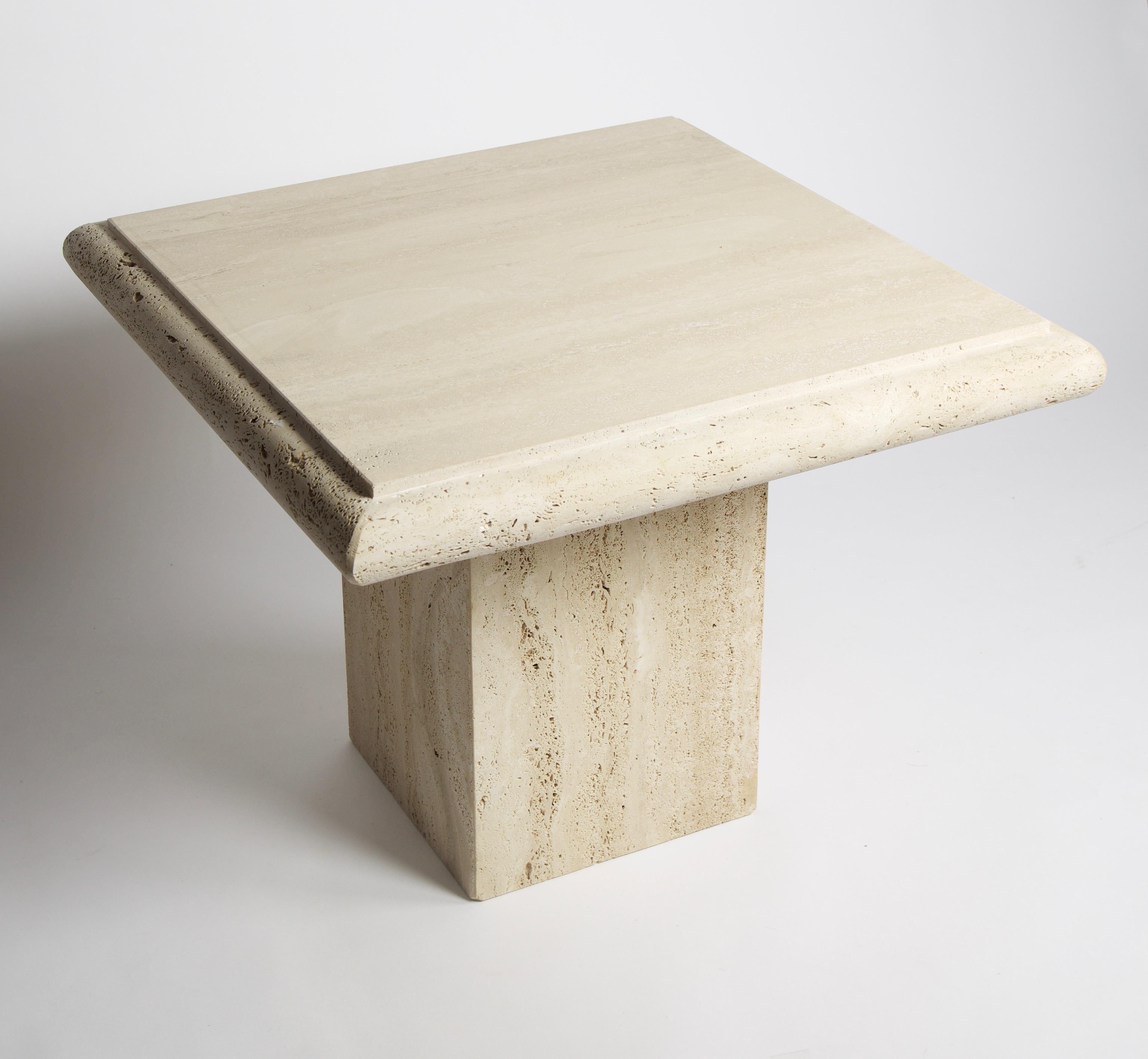 A vintage solid travertine table on a pedestal created by Stone International which was founded in 1975 just outside of Florence, Italy, the heartland of art and fashion. The table's top surface is filled and polished in contrast to the round