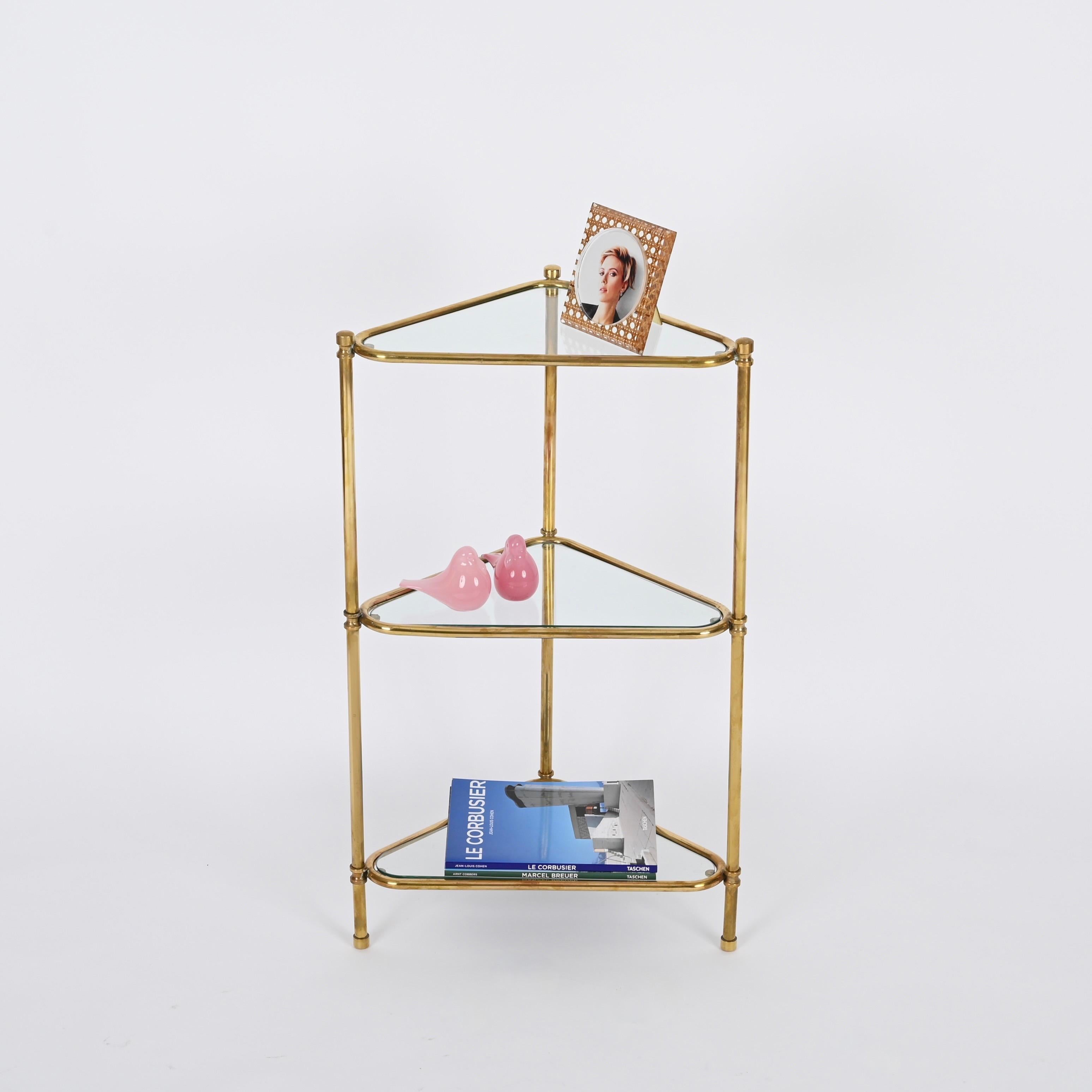 Gorgeous Italian corner shelf in solid brass with three triangular shelves. This elegant corner shelf was produced in Italy during the 1970s. 

In amazing condition, the brass has a beautiful golden tone, perfect for adding a touch of vintage luxury