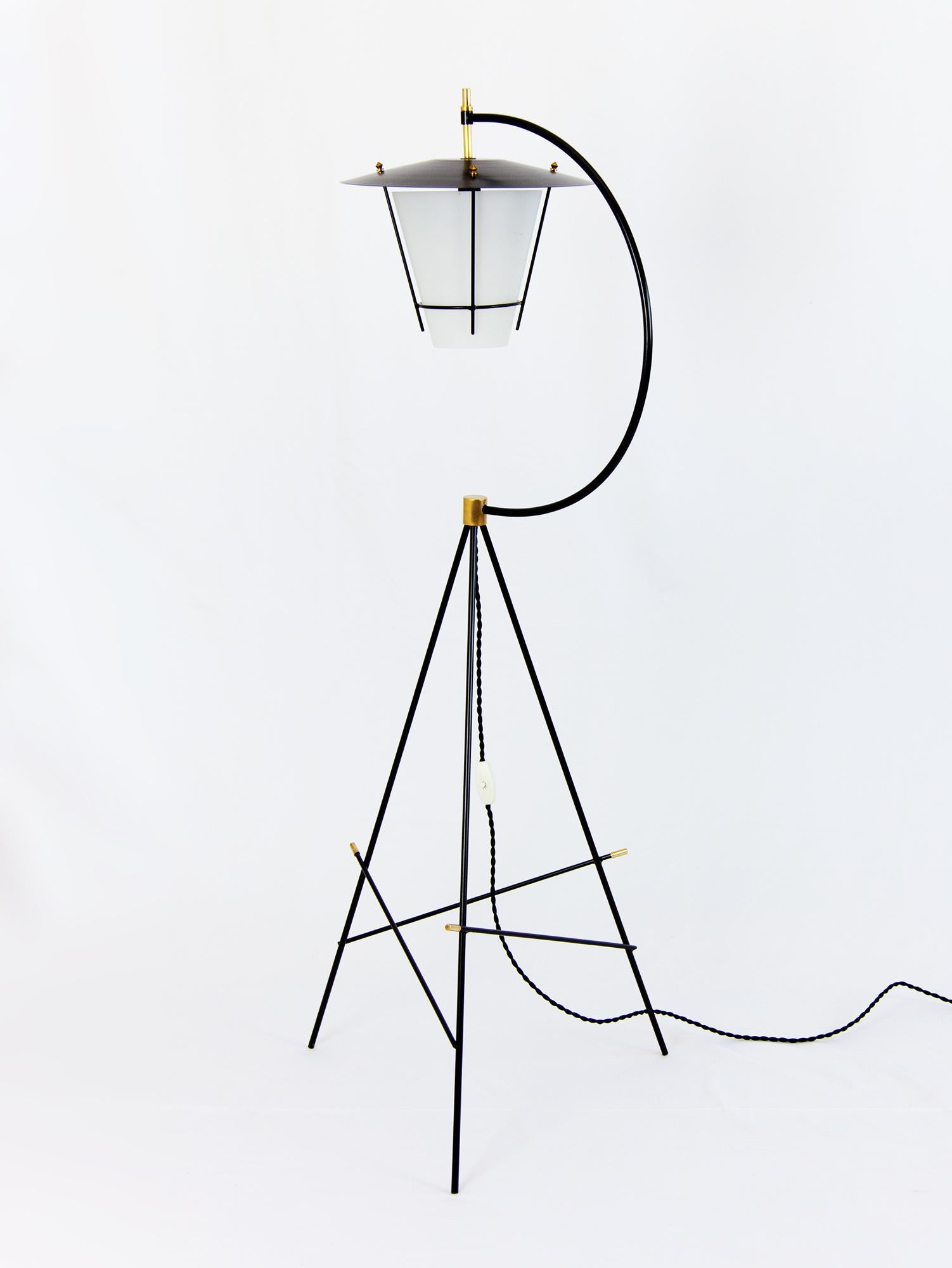 Stunning Italian tripod floor lamp with a solid black metal stand, satin glass shade and brass details. The lamp epitomises the 50s Italian aesthetic with a playful balance of angular lines and curves. Beautiful craftsmanship is seen throughout from