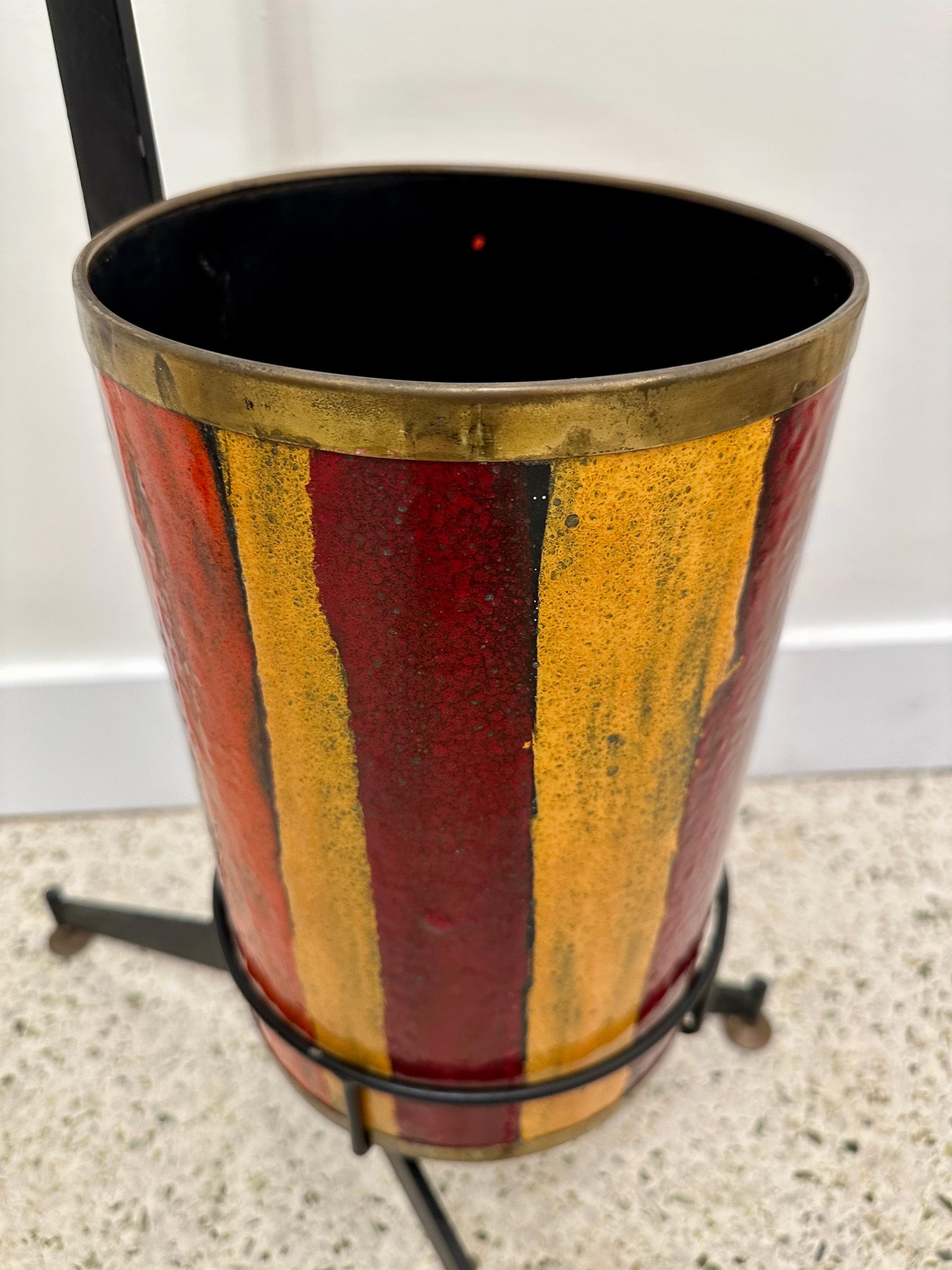 We LOVE this vividly colored enamel umbrella stand which sits in a very chic black iron stand with handle for easy movement.  The bucket is removeable and enameled in rich colors (yellow, burgundy and yellow) - ALL trimmed with a patinated brass