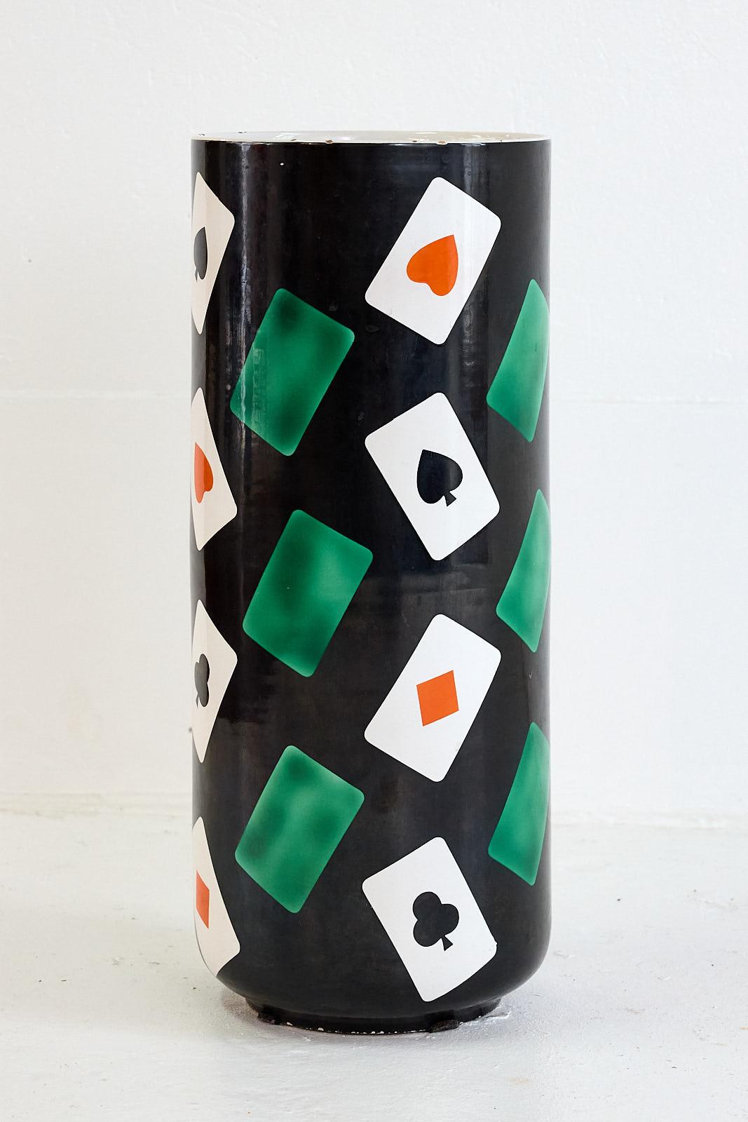 Wunderschöner Schirmständer aus Keramik aus den 1950er Jahren mit handgemaltem Dekor, das ein dramatisches schwarzes Feld zeigt, das Spielkarten in satten Grün- und Rottönen hervorhebt. Sie hat eine zylindrische Form und trägt auf der Unterseite die