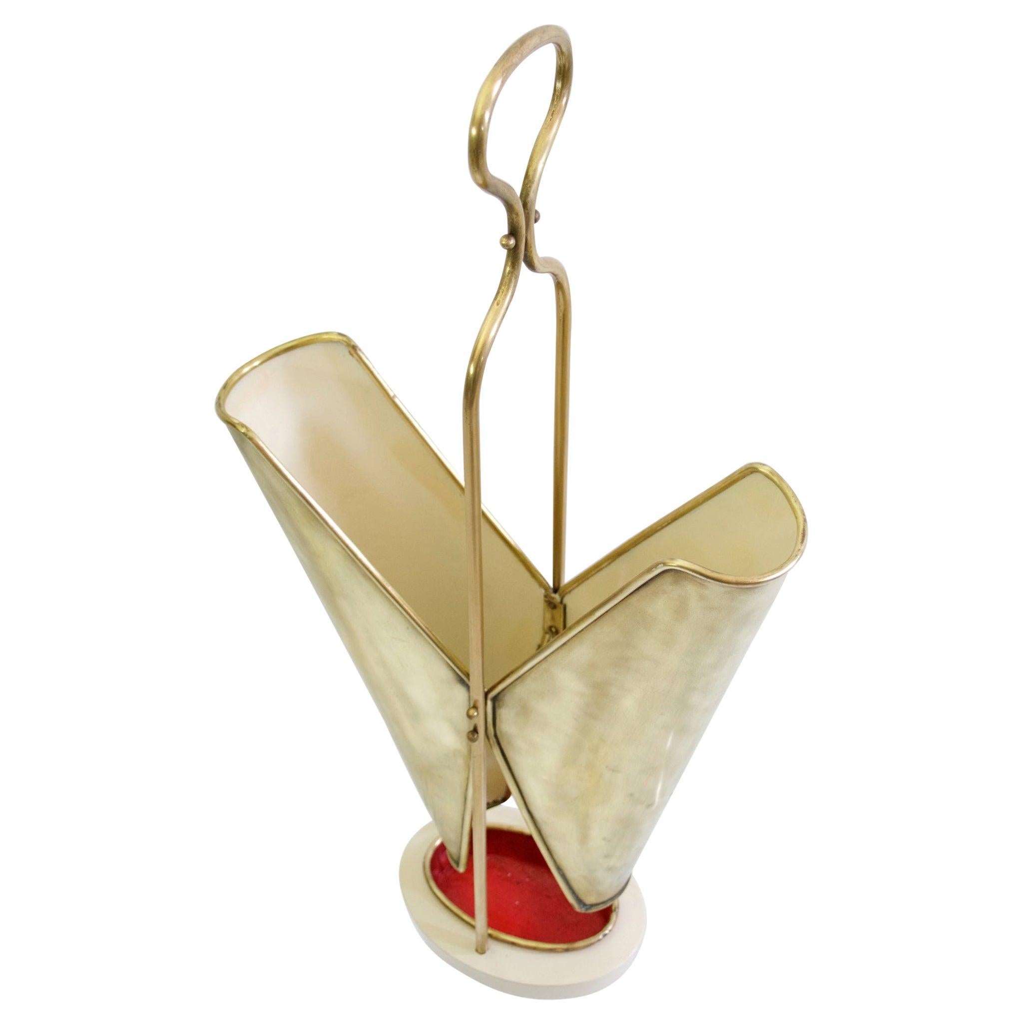 Super elegant umbrella stand in brass with the inside painted white, standing on an iron base. The water cup is in original condition painted red inside.