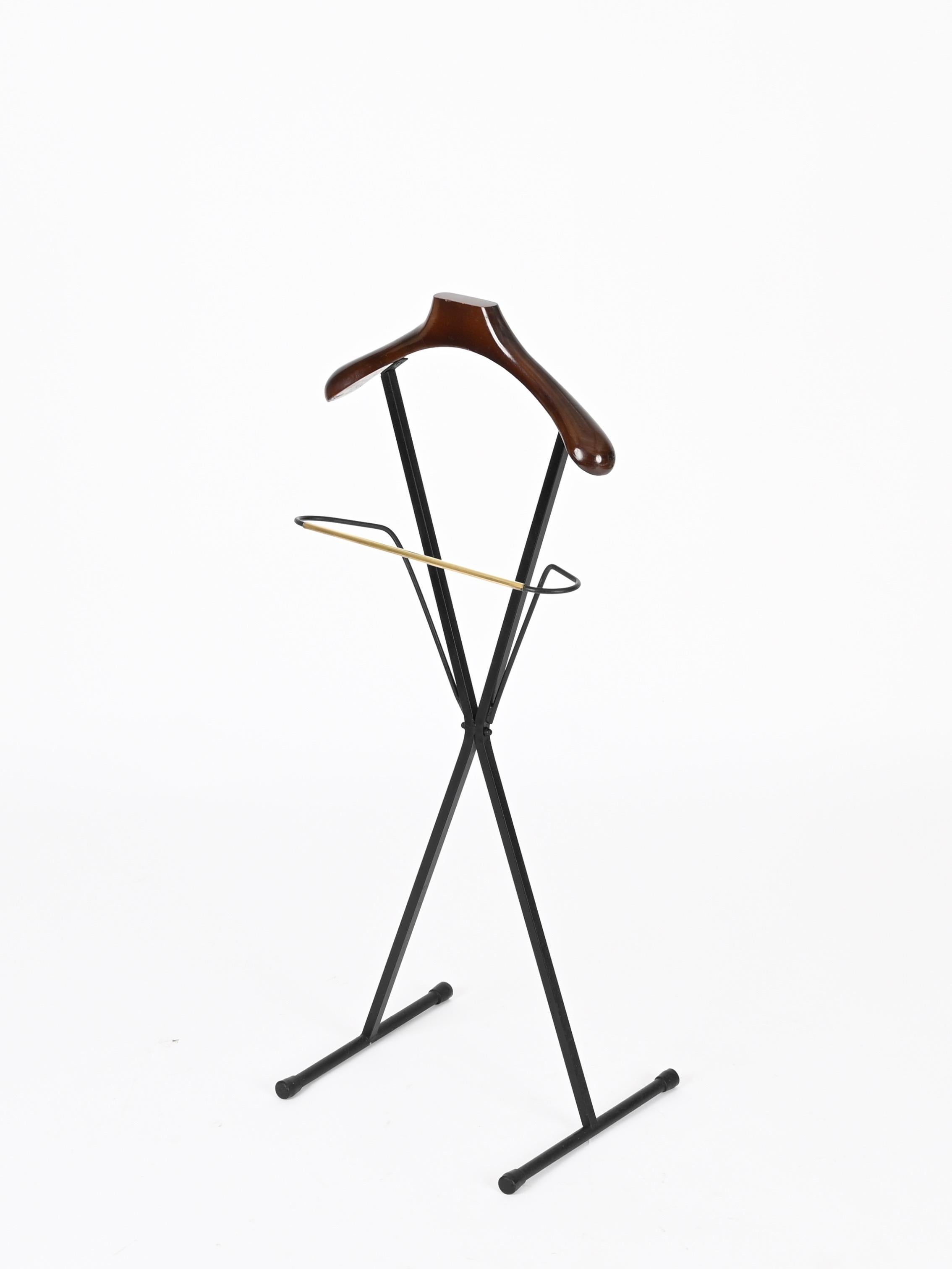 Merveilleux porte-valise du milieu du siècle en métal émaillé noir, hêtre teinté et laiton. Cette pièce élégante a été conçue et fabriquée par Fratelli Reguitti en Italie dans les années 1960.

Cette pièce élégante se compose d'un élégant cadre en