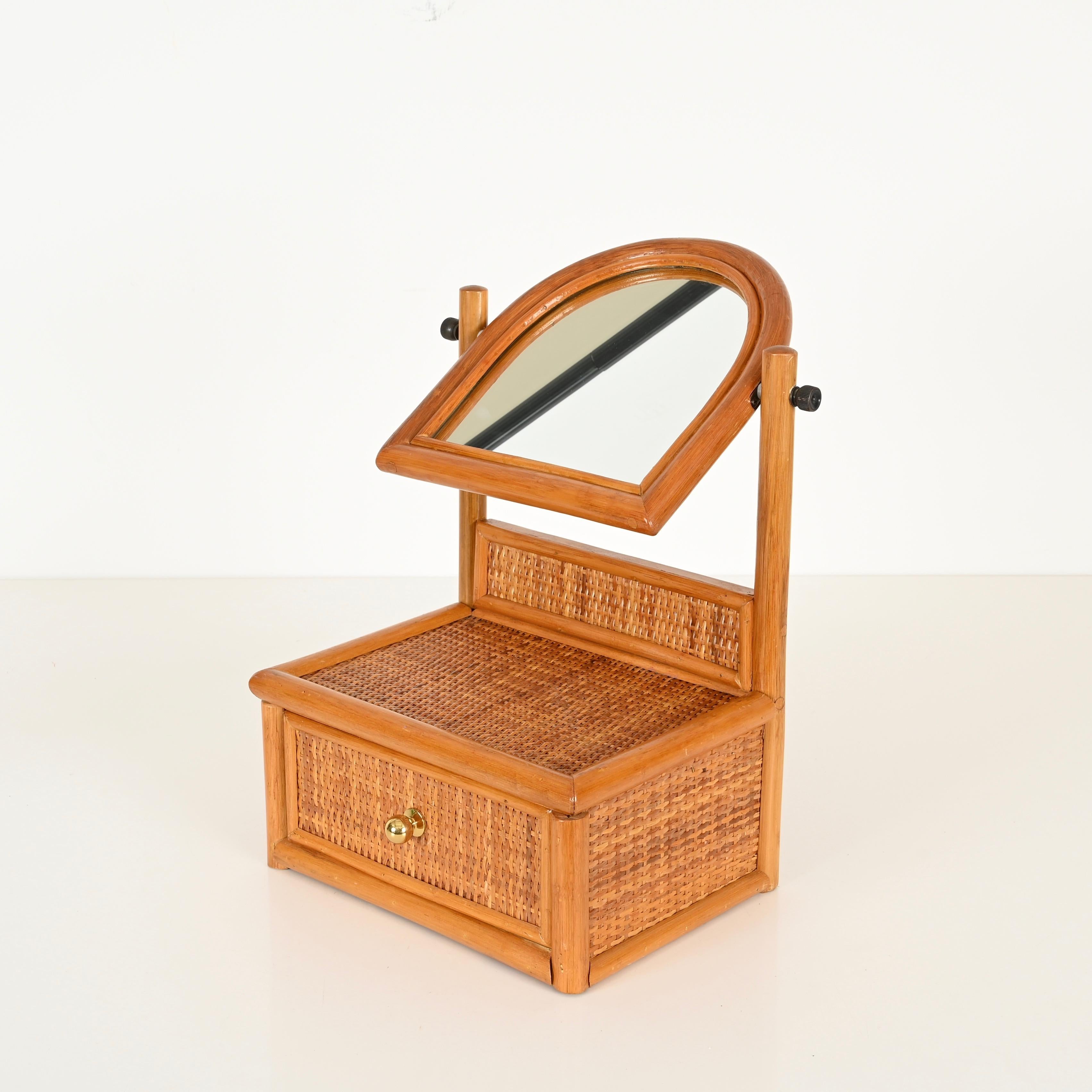 Merveilleux miroir de table ajustable avec tiroir, réalisé dans une magnifique combinaison de bambou, d'osier tressé et de laiton. Cette pièce organique incroyablement élégante et unique a été conçue en Italie dans les années 1970.

En fabuleux état