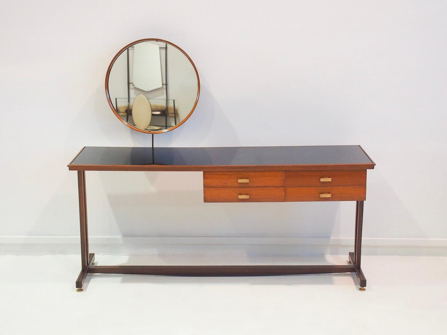 Wooden dressing table with round mirror made in Italy in the 1950s. The vanity has four drawers with brass handles, dark smoked glass table top and brass feet. Slight age-related wear, recently restored.