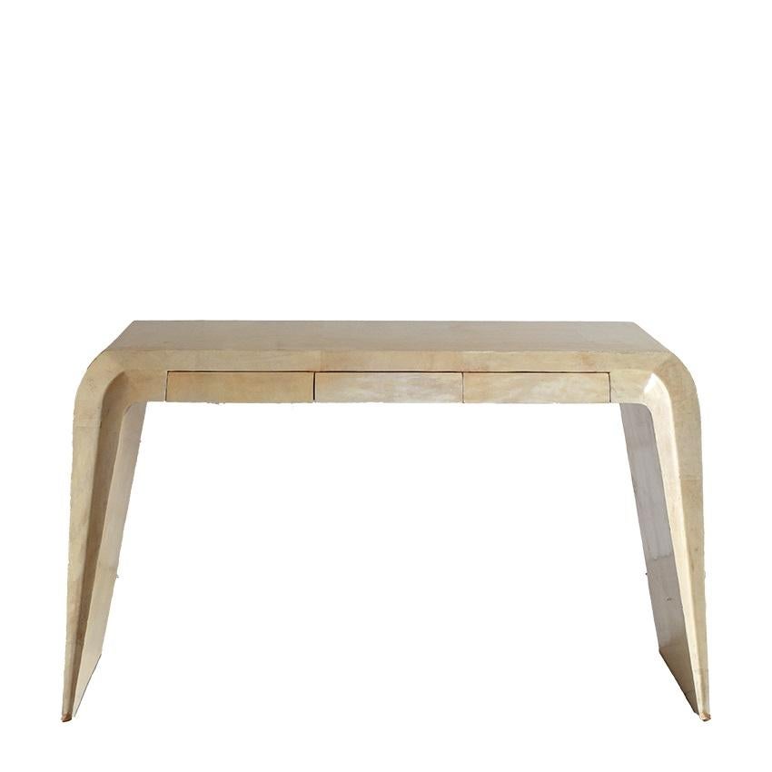 A console in true mid-century Italian style. Featuring a very unique design, with a curved top that descends forming the side and legs. In the central body there are three generous drawers concealed within the frame. The console is completely