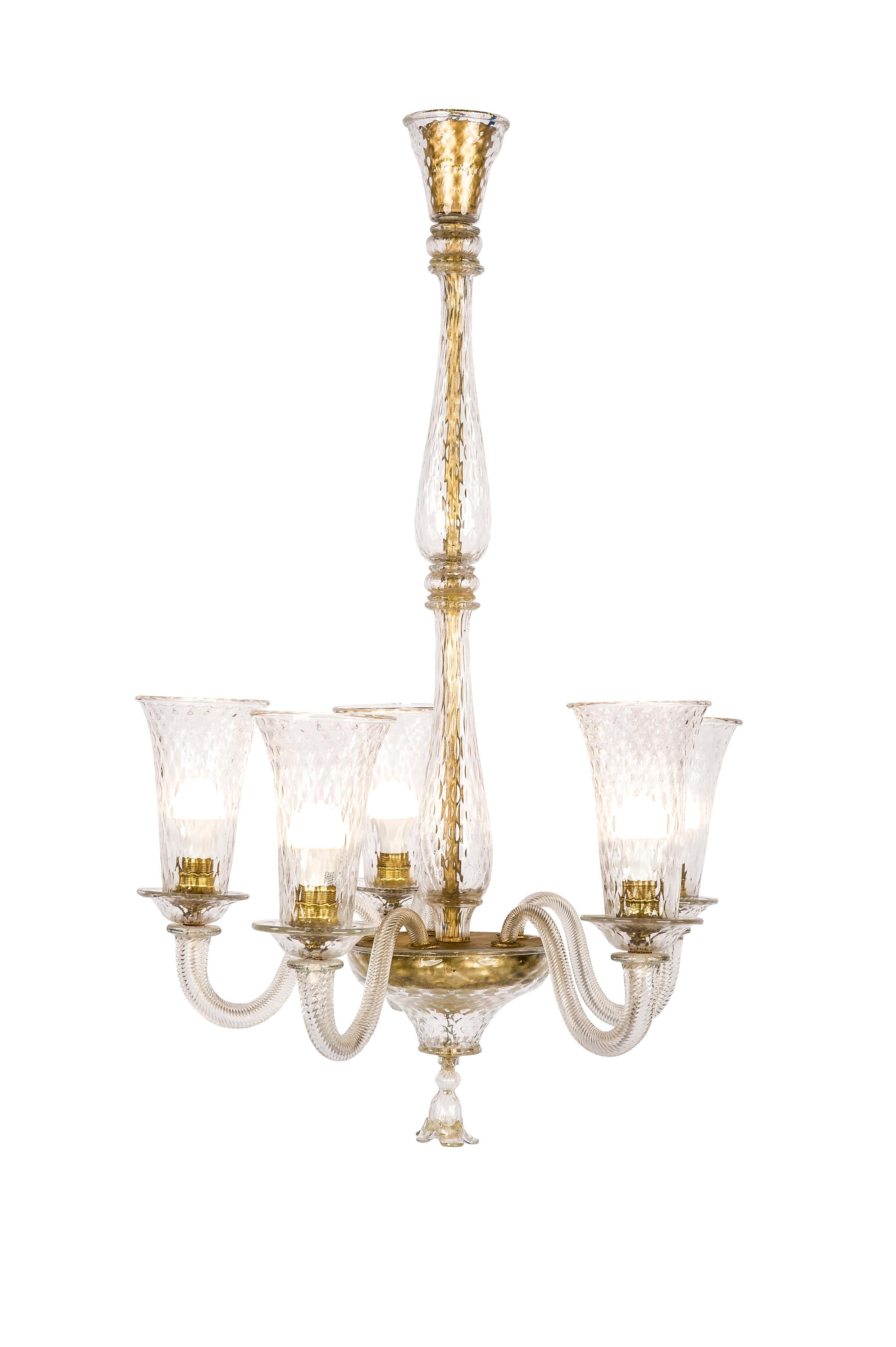 A beautiful Venetian five-arm chandelier made on the isle of Murano in Venice Italy. The chandelier was completely made in clear glass and some parts, 24-carat gold flakes were encapsulated in the glass. The piece has five fluted and twisted scroll