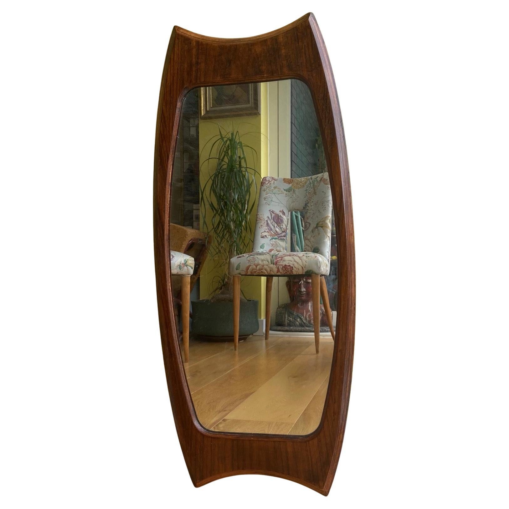 An elegant 1950s sculptured vertical Teak mirror, by Franco Campo and Carlo Graffi.