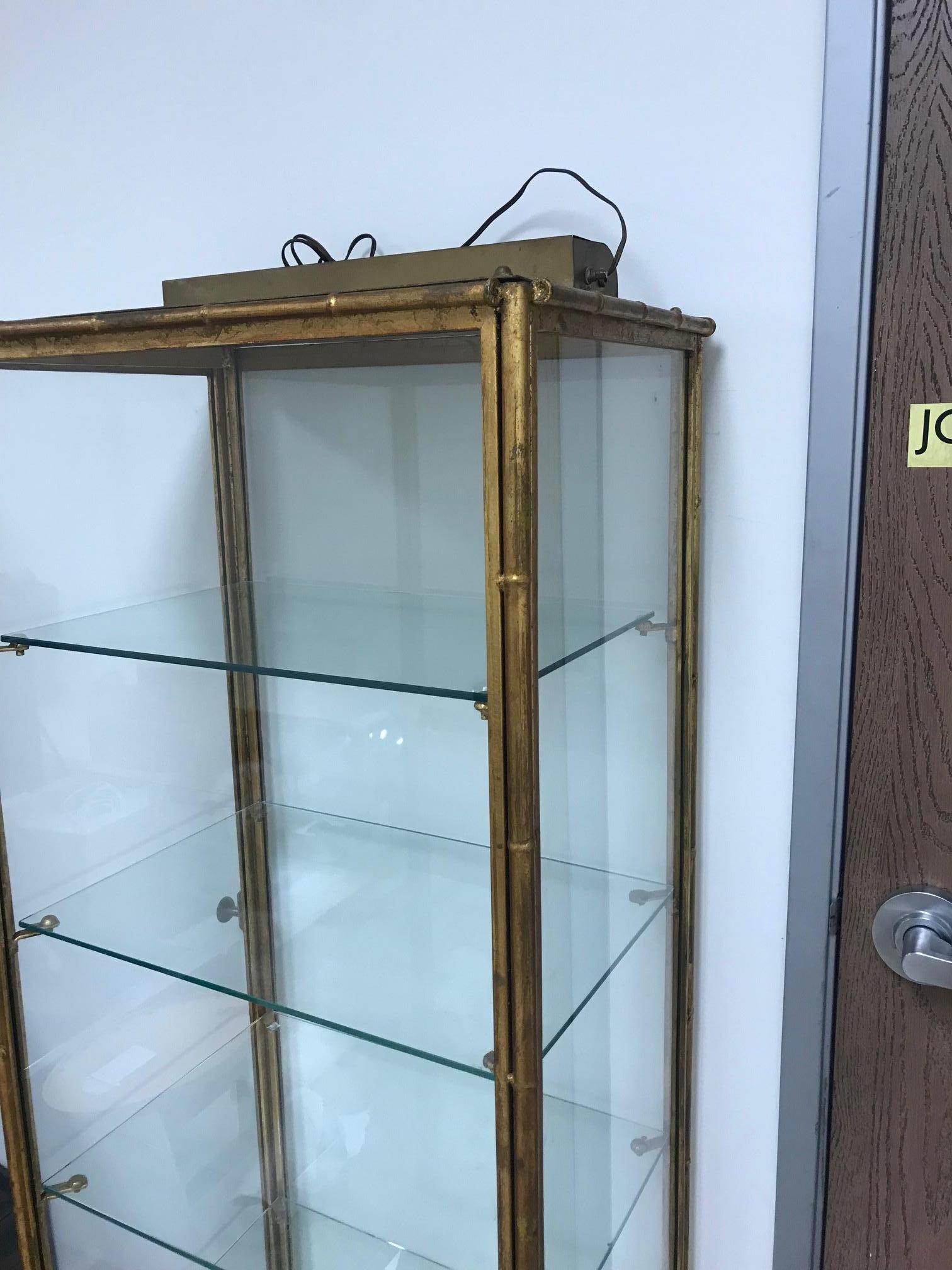 Painted gold on metal four glasses shelves Italian display case with top light.
Door open left side.
