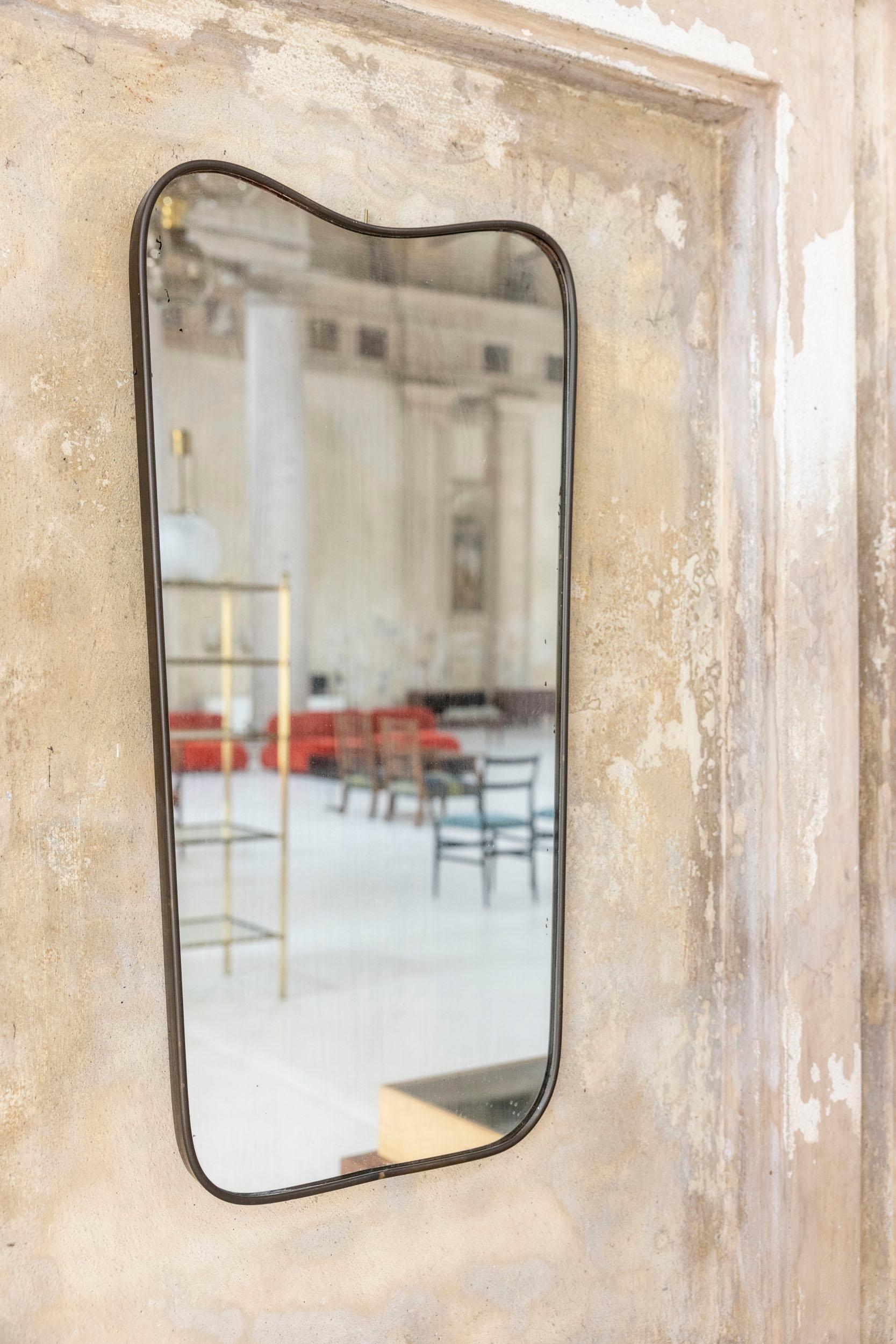 Specchio da parete italiano di metà secolo Attribuito a Gio Ponti, anni '50
Elegante specchio da parete di medie dimensioni attribuito a Gio Ponti, caratterizzato da una sinuosa cornice in ottone lavorata a mano. Lo specchio conserva il suo vetro di