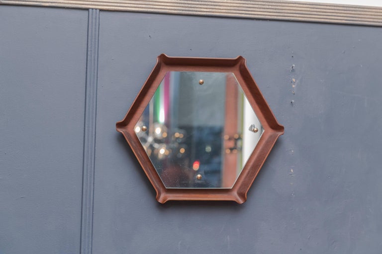 Unusual mid century Italian molded teak plywood wall mirror. The wood frame is in excellent vintage condition with a slight chip to the mirror plate at one of the mounting points.
