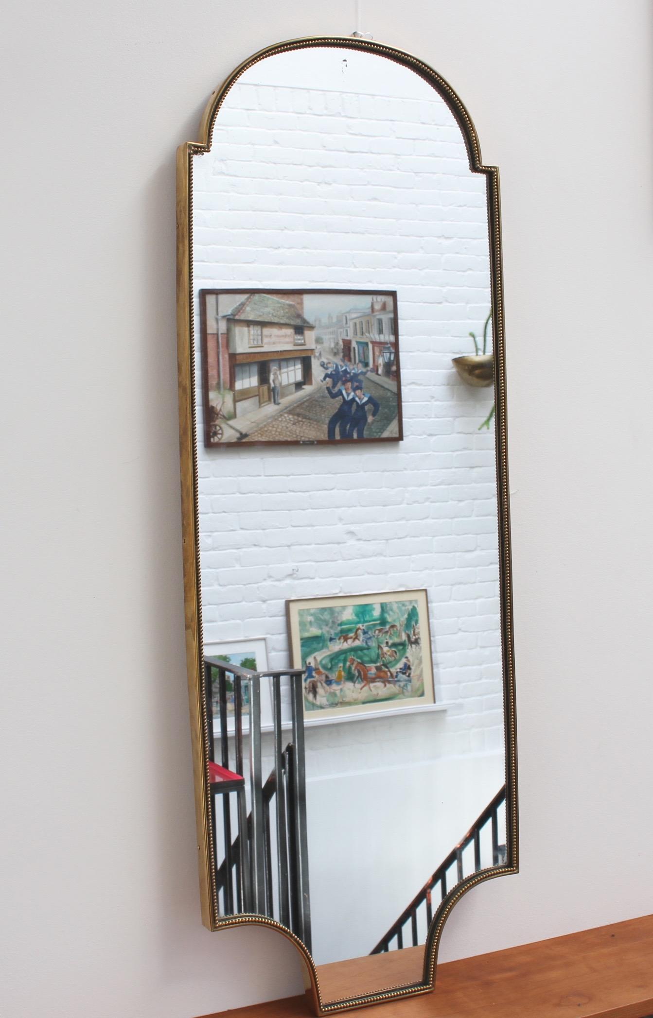 Midcentury Italian wall mirror with brass frame (circa 1950s). The mirror is lozenge-shaped, classically elegant and distinctive in a modern Gio Ponti style with a distinctive beaded detailing. This piece is in very good vintage condition. There are