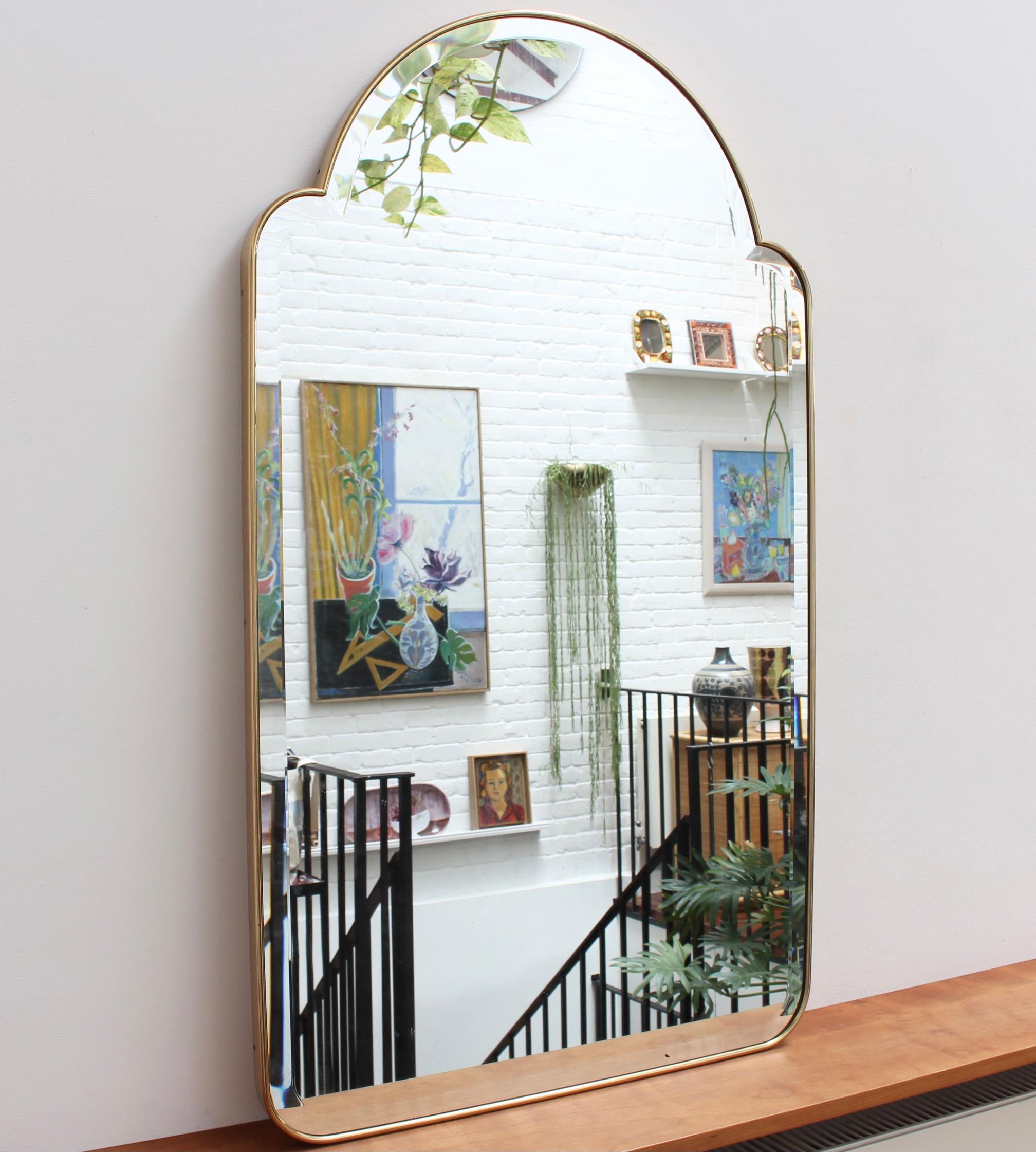 Mid-Century Italian wall mirror with brass frame (1950s). This bevelled mirror is simply elegant and characterful in a modern Gio Ponti style. In overall very good condition with a solid backing there is only a very tiny blemish on the glass (please