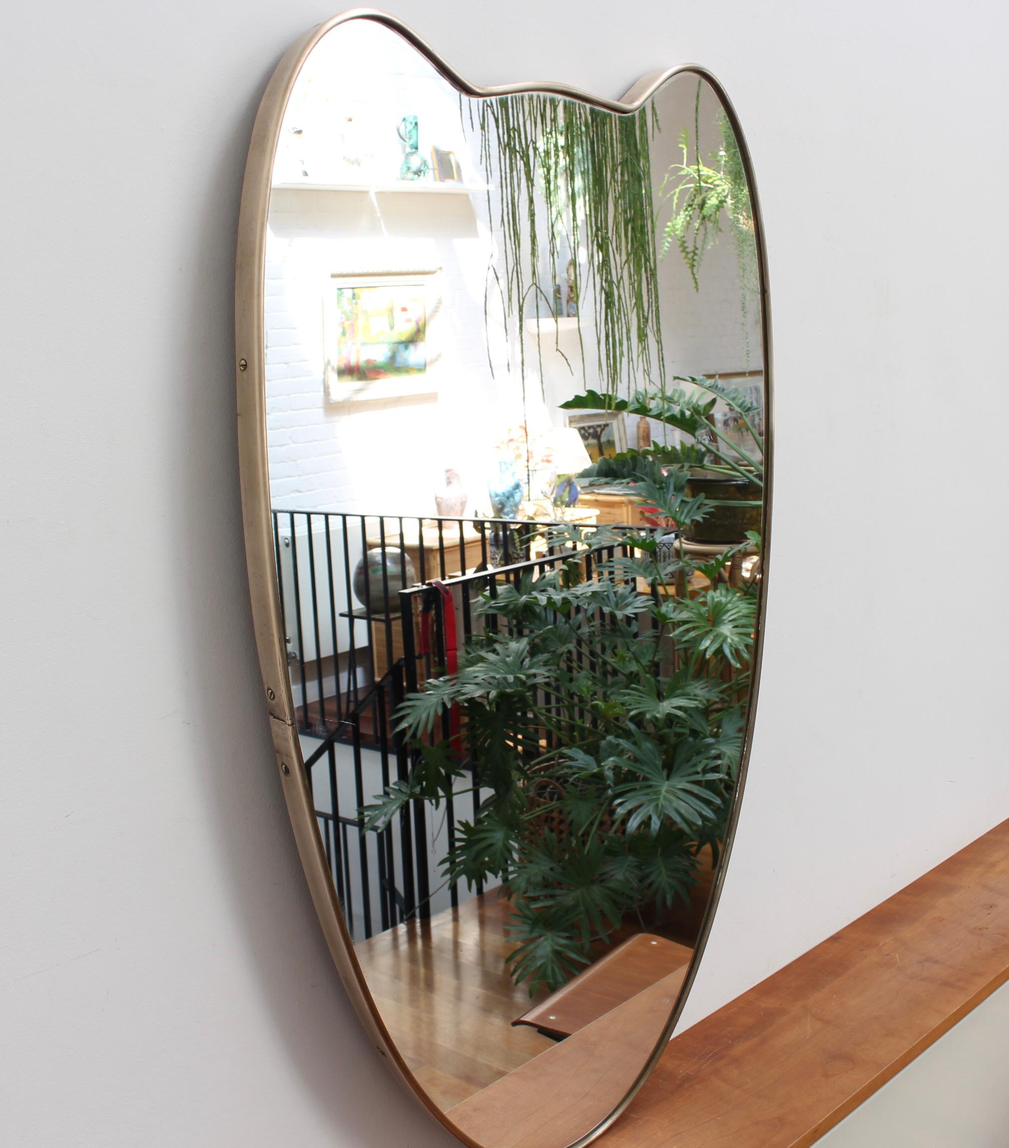 Midcentury Italian wall mirror with brass frame (circa 1950s). The mirror is classically-shaped and distinctive in a Modern style. It is in very good overall condition. A beautiful, aged patina will develop on the recently polished brass frame over