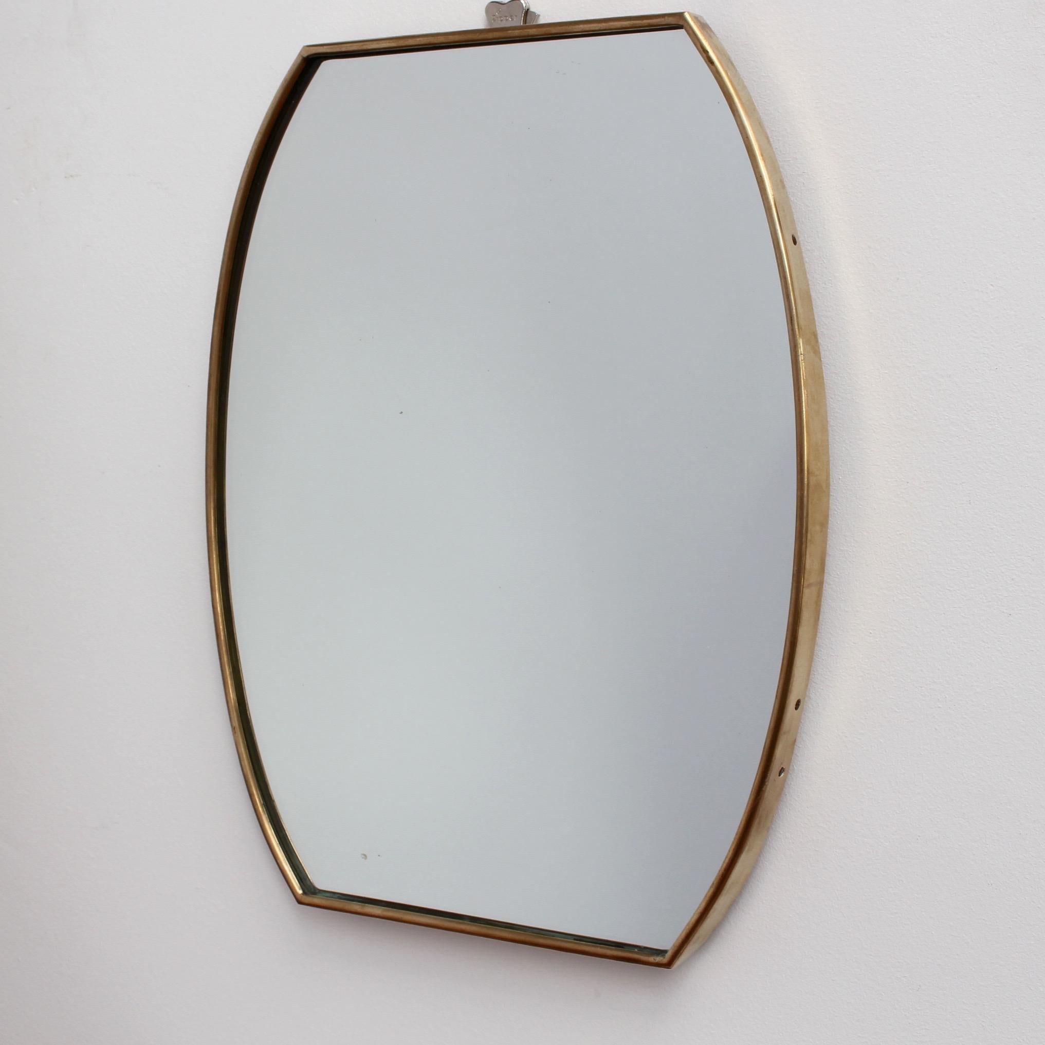 Small-scale midcentury Italian wall mirror with brass frame (circa 1950s). The mirror is barrel-shaped with sensuous curves. It is classically elegant and distinctive in a modern Gio Ponti style. This mirror is in good vintage condition. There is