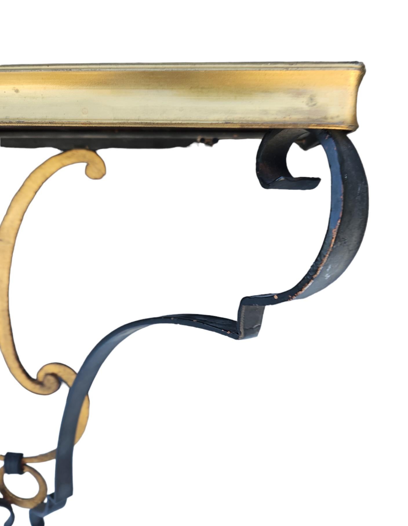 A wall-mounted Italian brass and iron console with replaced beveled mirror top.  Brass... could be bronze.  Very pretty and unusual.