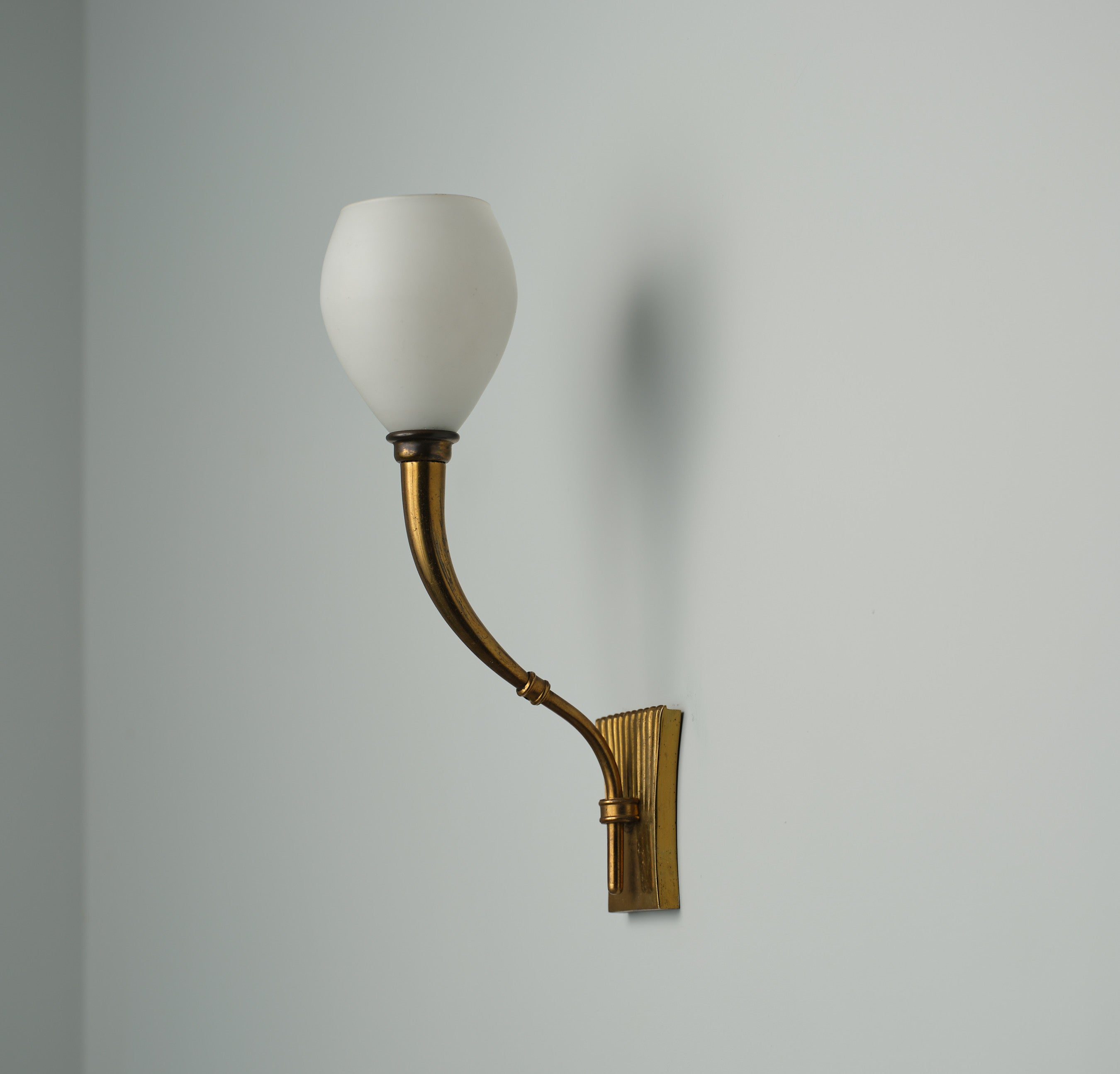 Dieser italienische Wandleuchter, der Fontana Arte aus den 1950er Jahren zugeschrieben wird, zeichnet sich durch ein Design aus, das Funktionalität mit understated.design verbindet. Die Leuchte besteht aus Messing, das im Laufe der Zeit auf