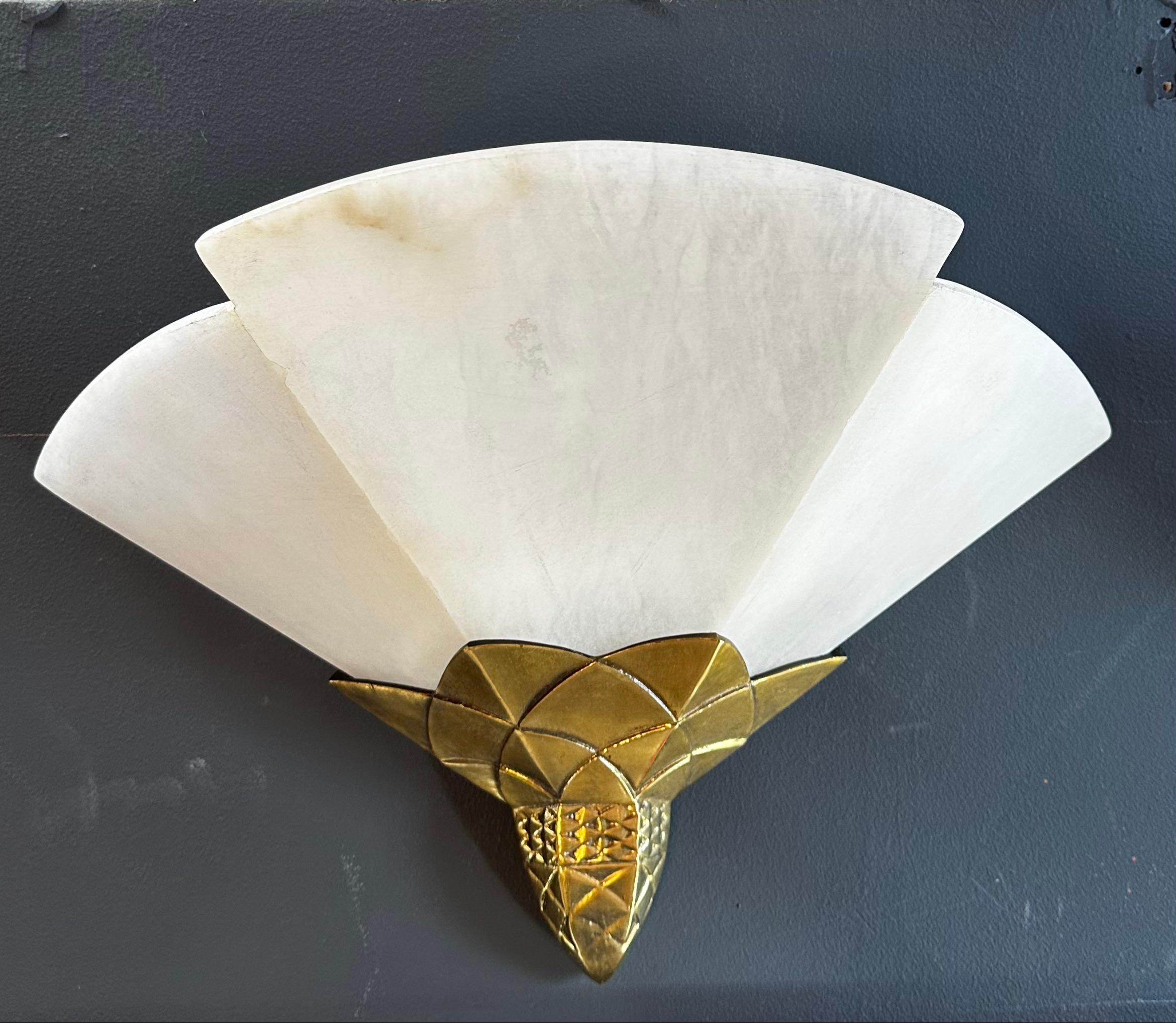 These wall sconces are a beautiful example of Mid-Century Modern design, featuring a simple yet elegant combination of brass and marble. Each sconce consists of a rectangular brass frame that is mounted on the wall, with a curved arm extending