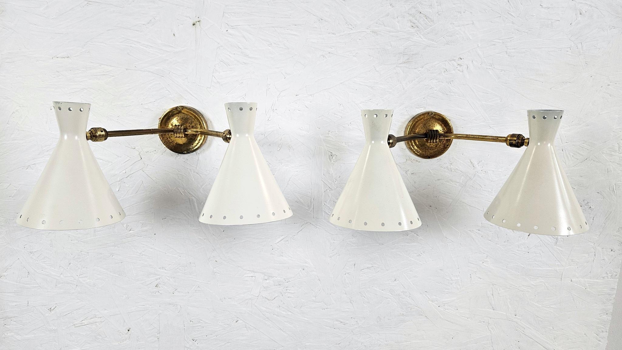 Classic pair of ivory white and gold 1950's wall lights in the manner of Stilnovo Italy. The light cones is adjustable in all angles. The coating is new and in good condition and the brass has been kept as it is with signs of age which only proves