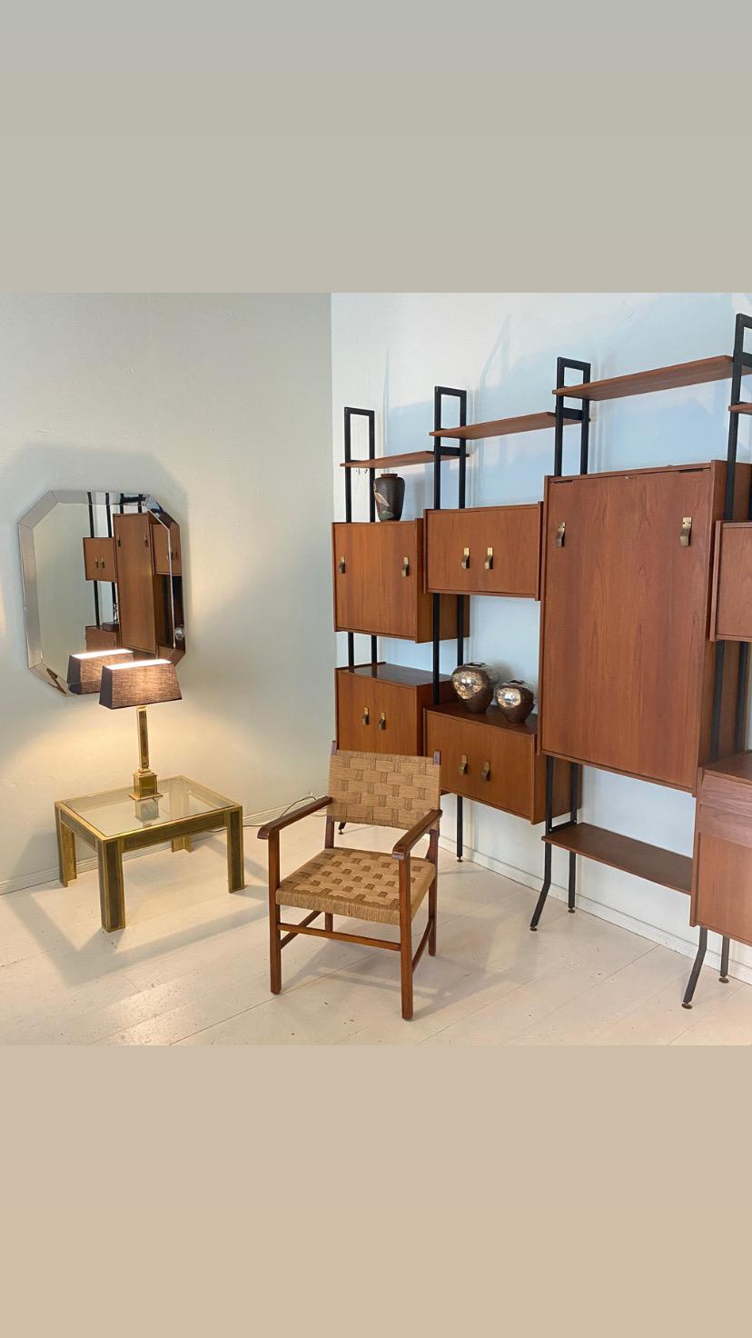 This beautiful mid century Italian wall unit or shelving system was designed and made in Italy, around 1950. It is made out of teak and black lacquered metal.
The corpora are beautiful made out of veneered teak. There is a bar unit and also a