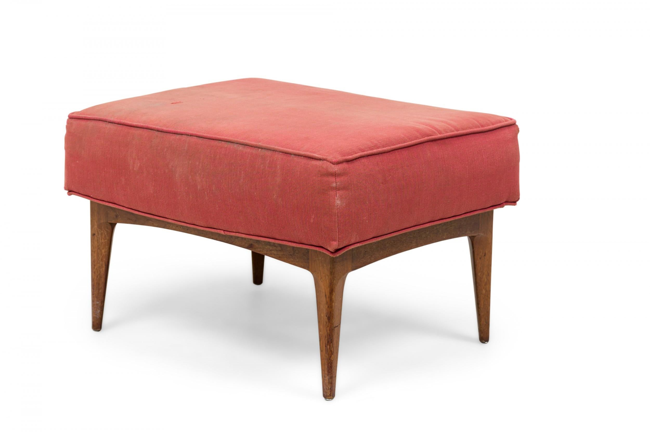 Midcentury Italian walnut rectangular ottoman with muted red fabric upholstered seat and piping, standing on four tapered legs.