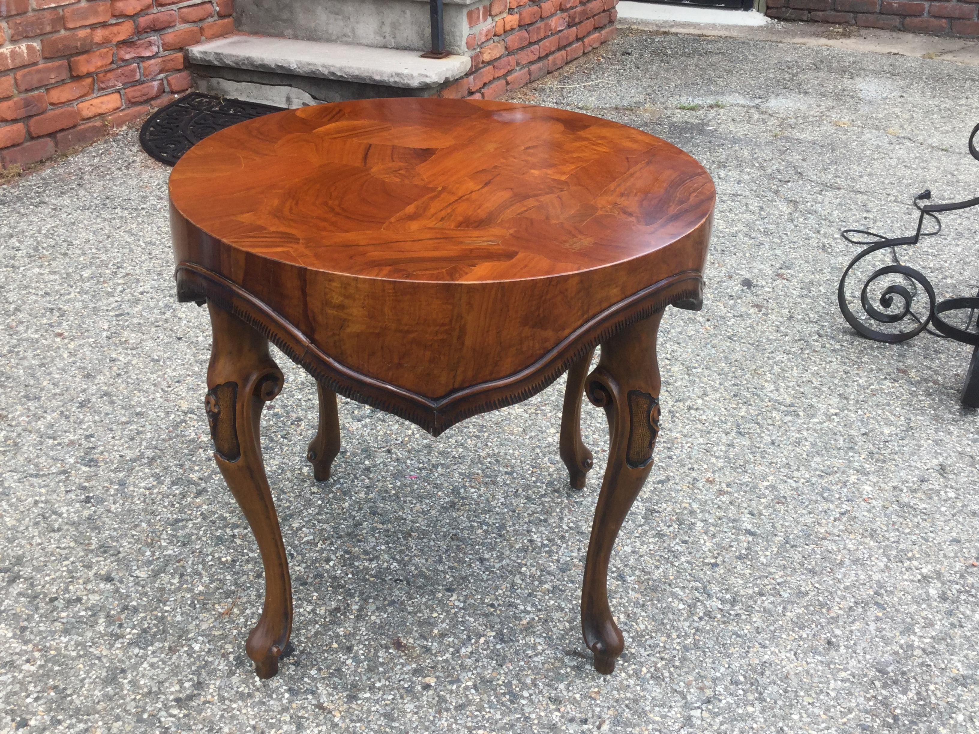 Elegant midcentury Italian end table. Made of walnut, this table features an unusual draped apron. The top is made of multiple veneers for a beautiful mosaic effect. This table can be used as a side table in a bedroom or living room. It can also