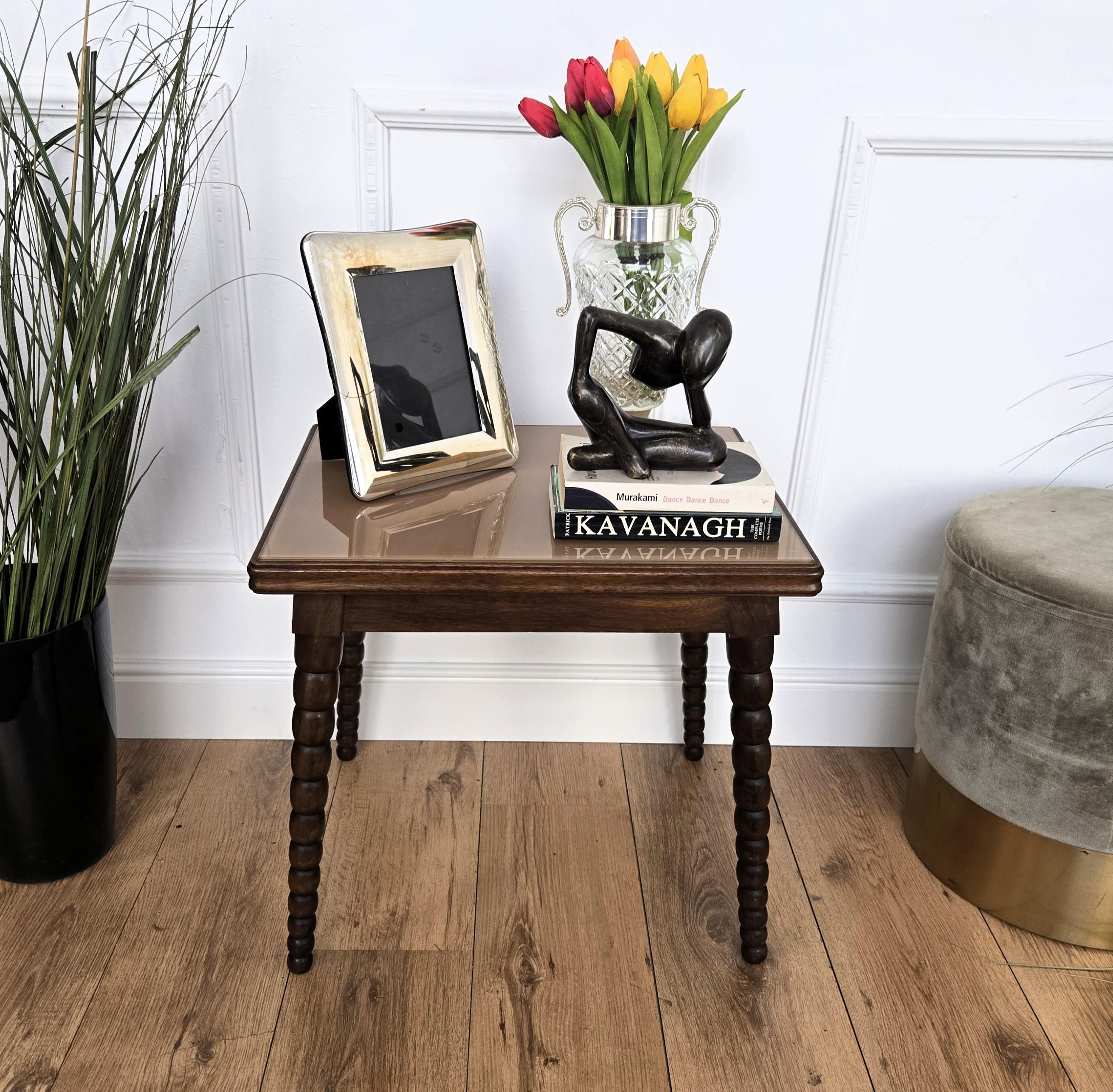 Cette magnifique table d'appoint italienne est dotée d'un plateau en verre encadré aux bords biseautés et repose sur quatre pieds en orge magnifiquement tournés aux fuseaux. Cette table basse d'appoint à la patine riche et magnifique fera merveille