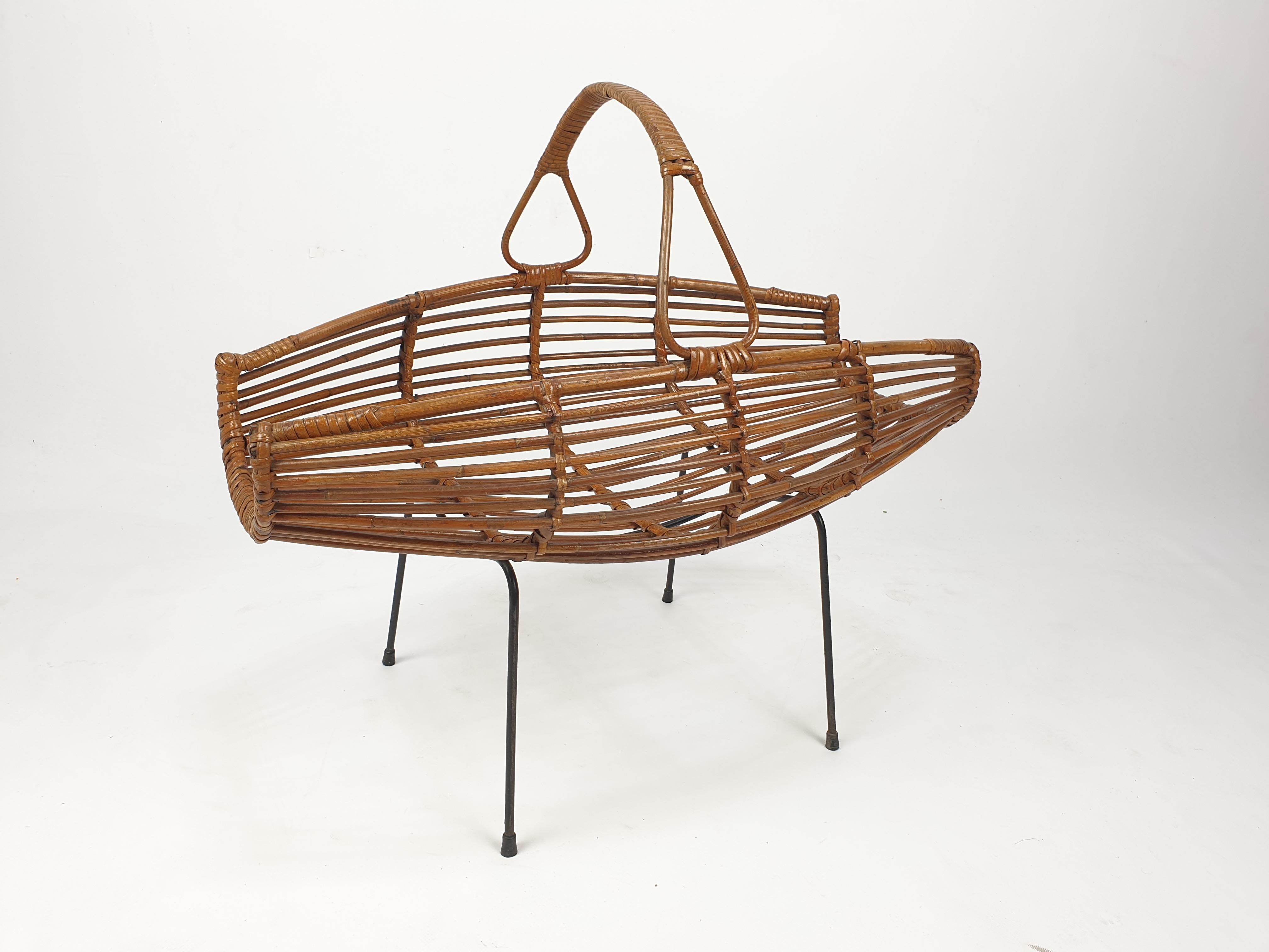 Very stylish midcentury wicker magazine rack from Italy. 
Made with nice round shapes. 

The airy and light feel of the organic cane, and the more modern feel of the dark steel creates a great balance. 

Wicker furniture, such as this magazine