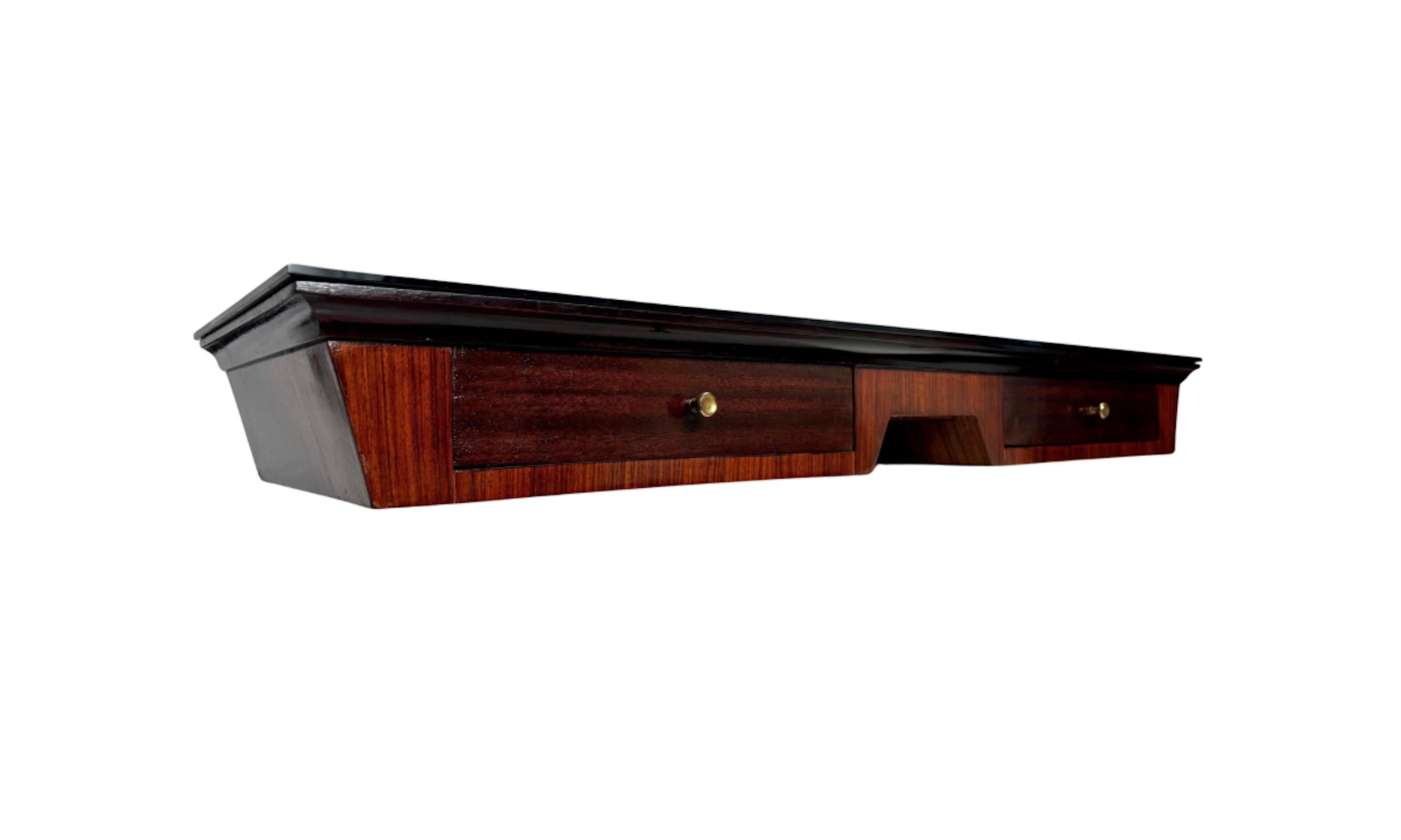 An elegant mid-century Italian rosewood wall console table with a black glass top and brass knobs.

Designed for an elegant Florentine apartment, the console table stands out for its geometric rigor and the richness of its materials.

Ask us for a