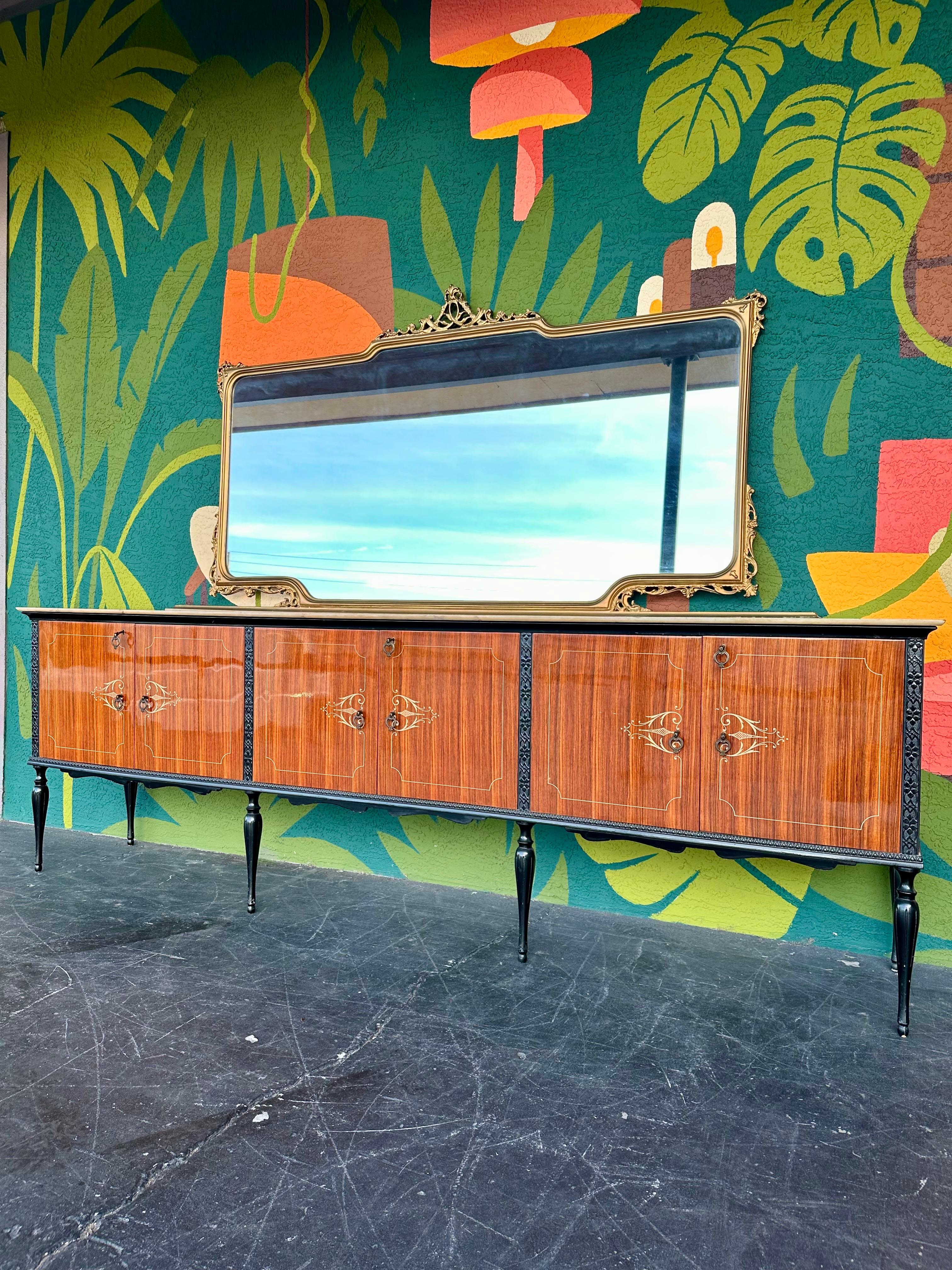 Italian high gloss wood credenza with black lacquer legs and trim, and marble top. Extra long at 110.5”W with Carrara marble top, perched atop long shapely legs, beautiful wood grain inside and out highlighted by the glossy finish and a white