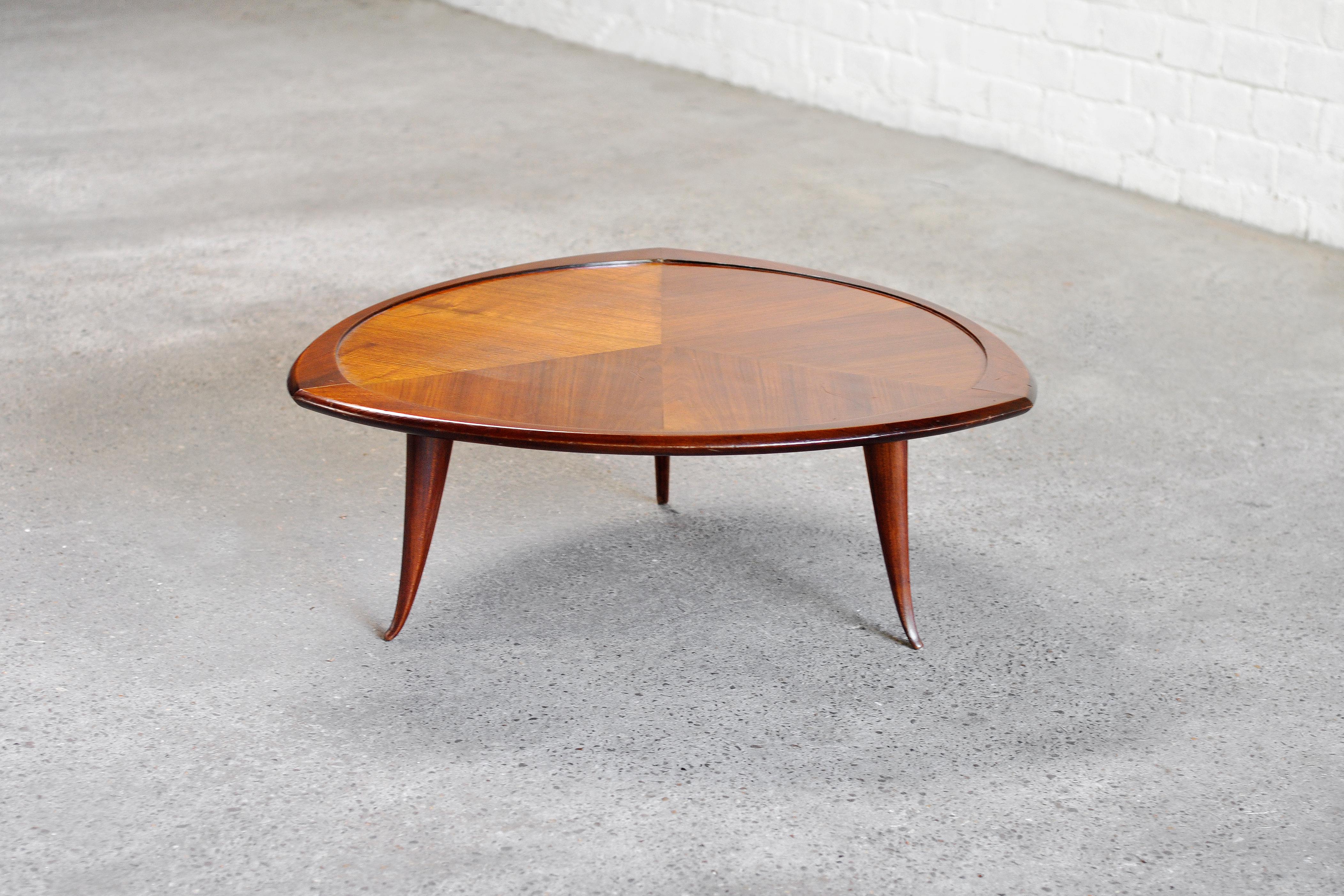 A 1960's Italian designer coffee table crafted from a blend of various wood types. Thanks to its distinctive and uniquely shaped tabletop, this table exudes a decorative and unique aesthetic. The legs are sculpted into gently curving cones which