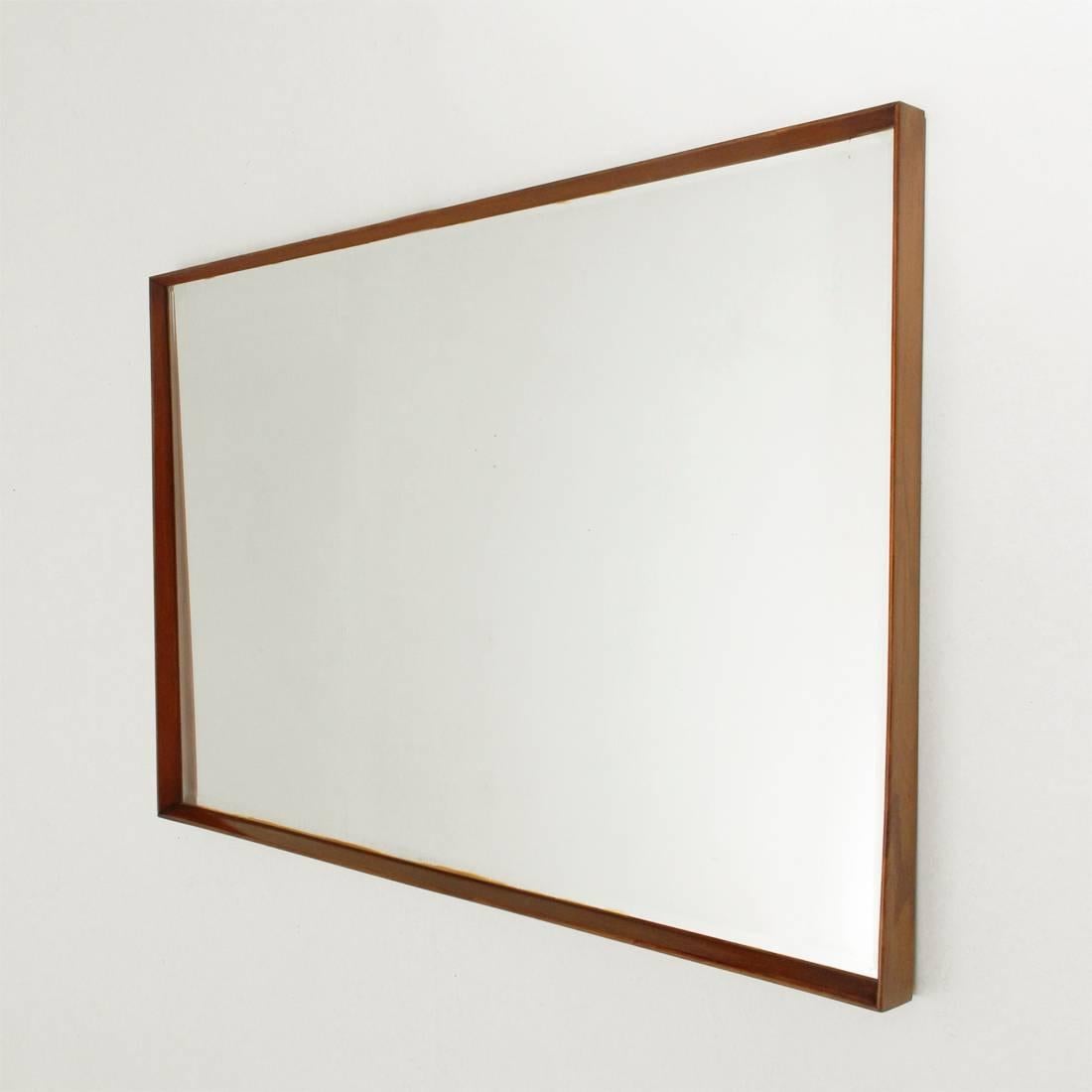 Italian mirror of 1950s production.
Trapezoidal wooden body, mirrored glass surface with bevelled edge and wooden frame.
Good condition, mirror with slight defects.

Dimensions: Top width 143 cm, bottom width 136 cm, depth 6 cm, height 88 cm.