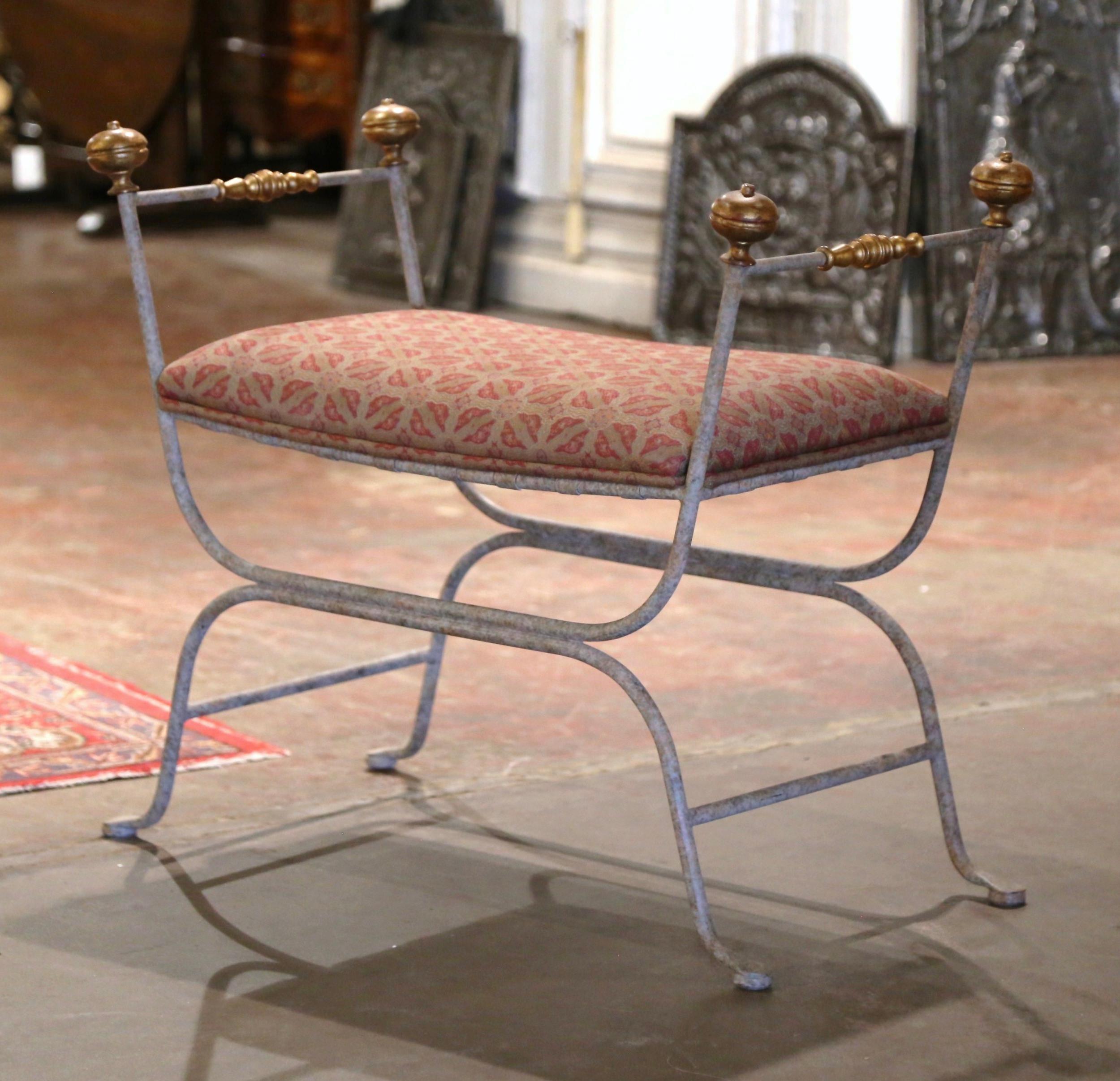 This elegant, antique Campaign bench was created in Italy, circa 1970. Made of forged iron, the seating has scrolled legs, and is embellished with decorative bronze rosette finials at each end of both armrests. The seat is upholstered with a thick