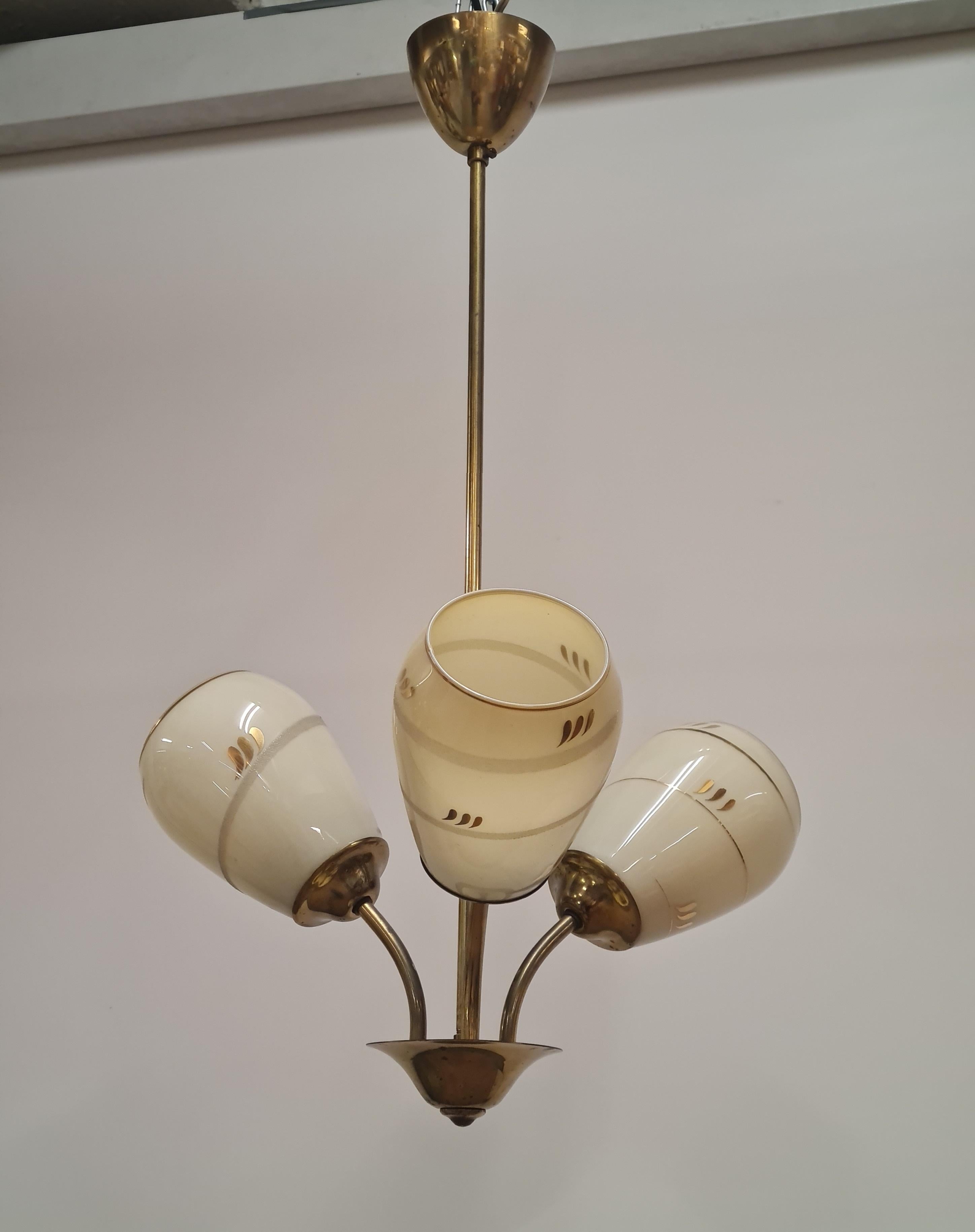 Una bellissima e delicata lampada da soffitto finlandese di metà secolo, modello ER 86/3 di Itsu, uno dei principali produttori di illuminazione della Finlandia. La lampada presenta tre basi luminose con paralumi in vetro opalino dipinto a mano.