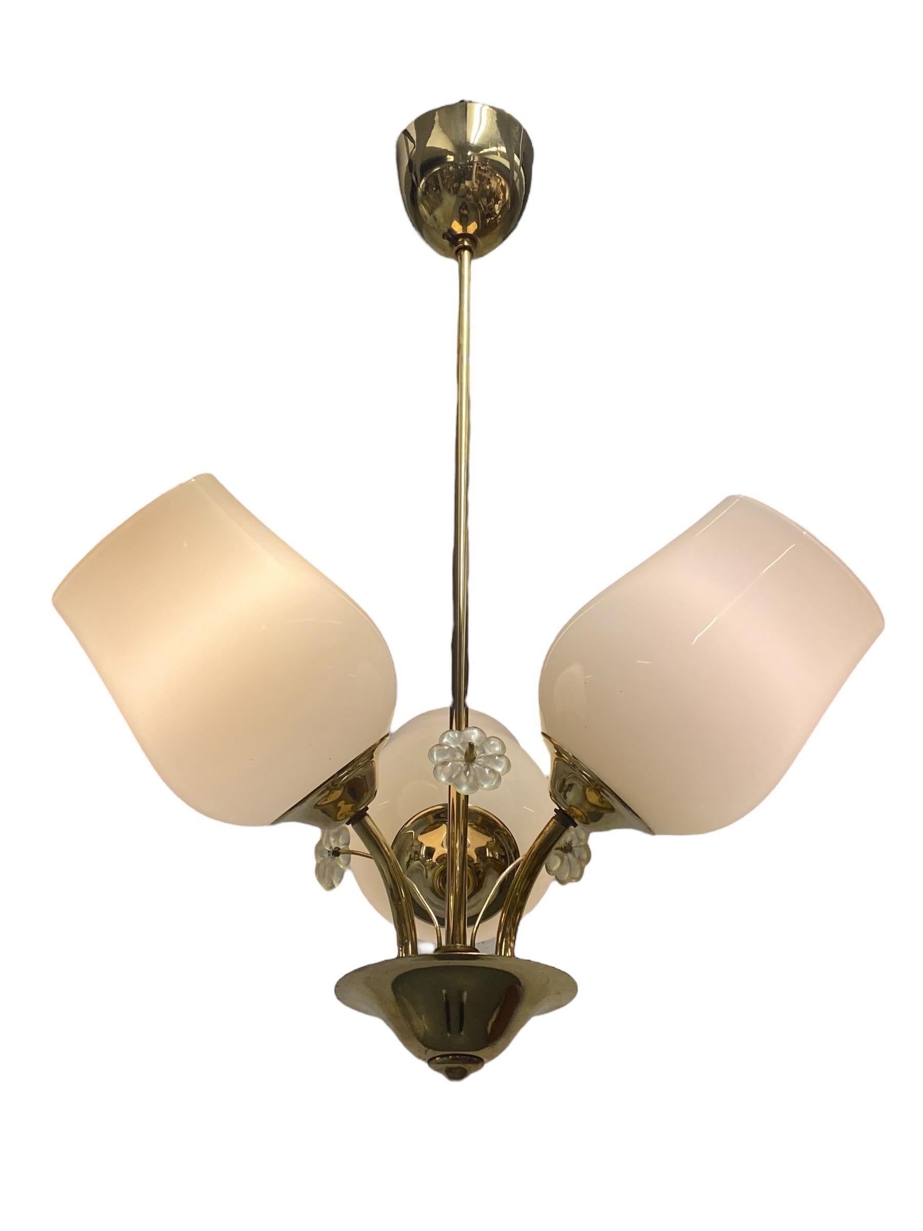 Una bellissima e delicata lampada da soffitto finlandese di metà secolo di Itsu, uno dei principali produttori di illuminazione della Finlandia. La lampada presenta tre basi luminose con paralumi in vetro opalino e decorazioni floreali in vetro tra