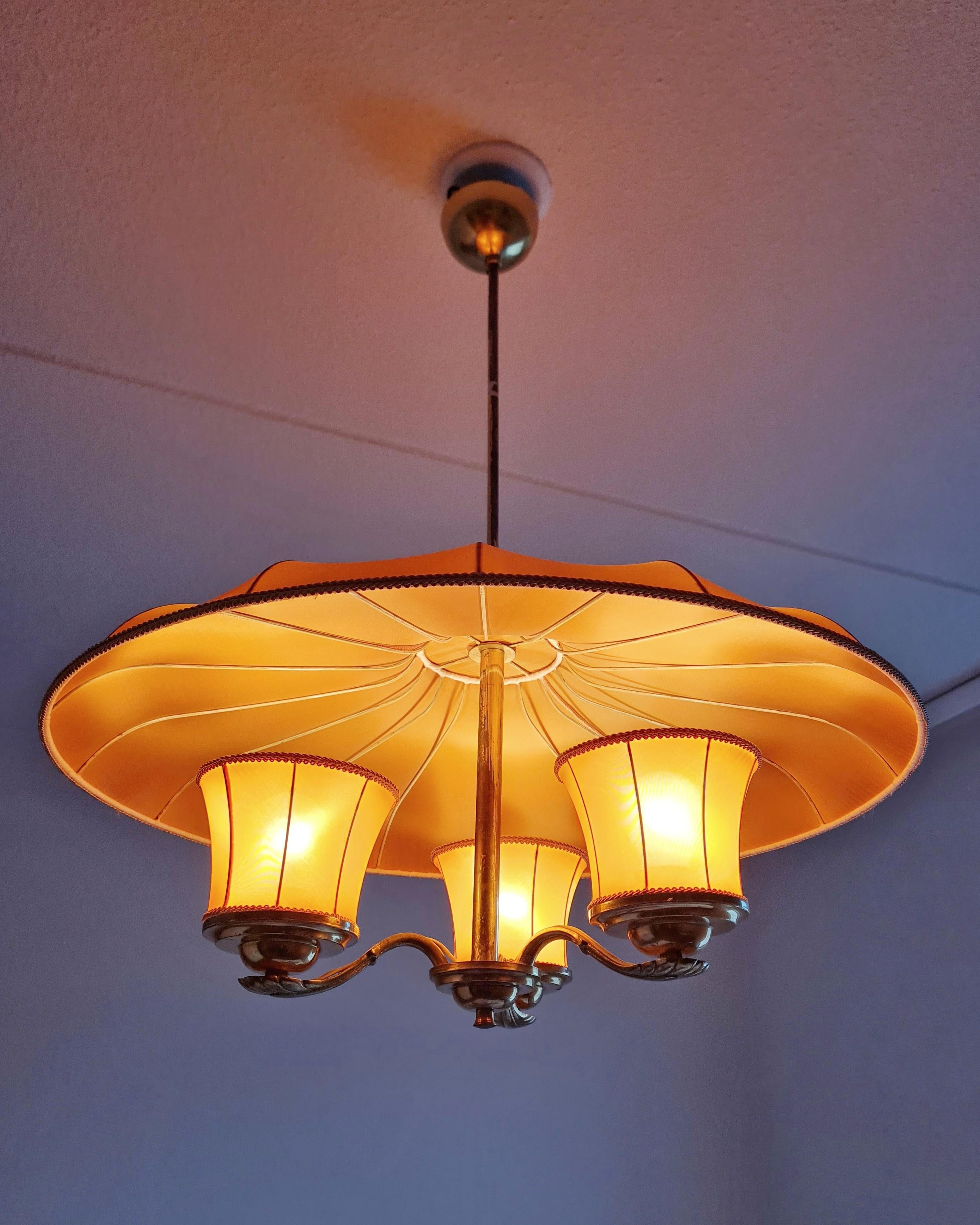 Una splendida e rarissima lampada da soffitto finlandese di metà secolo di Itsu, uno dei principali produttori di illuminazione della Finlandia. La lampada è in condizioni assolutamente originali con paralumi in tessuto originali. La lampada