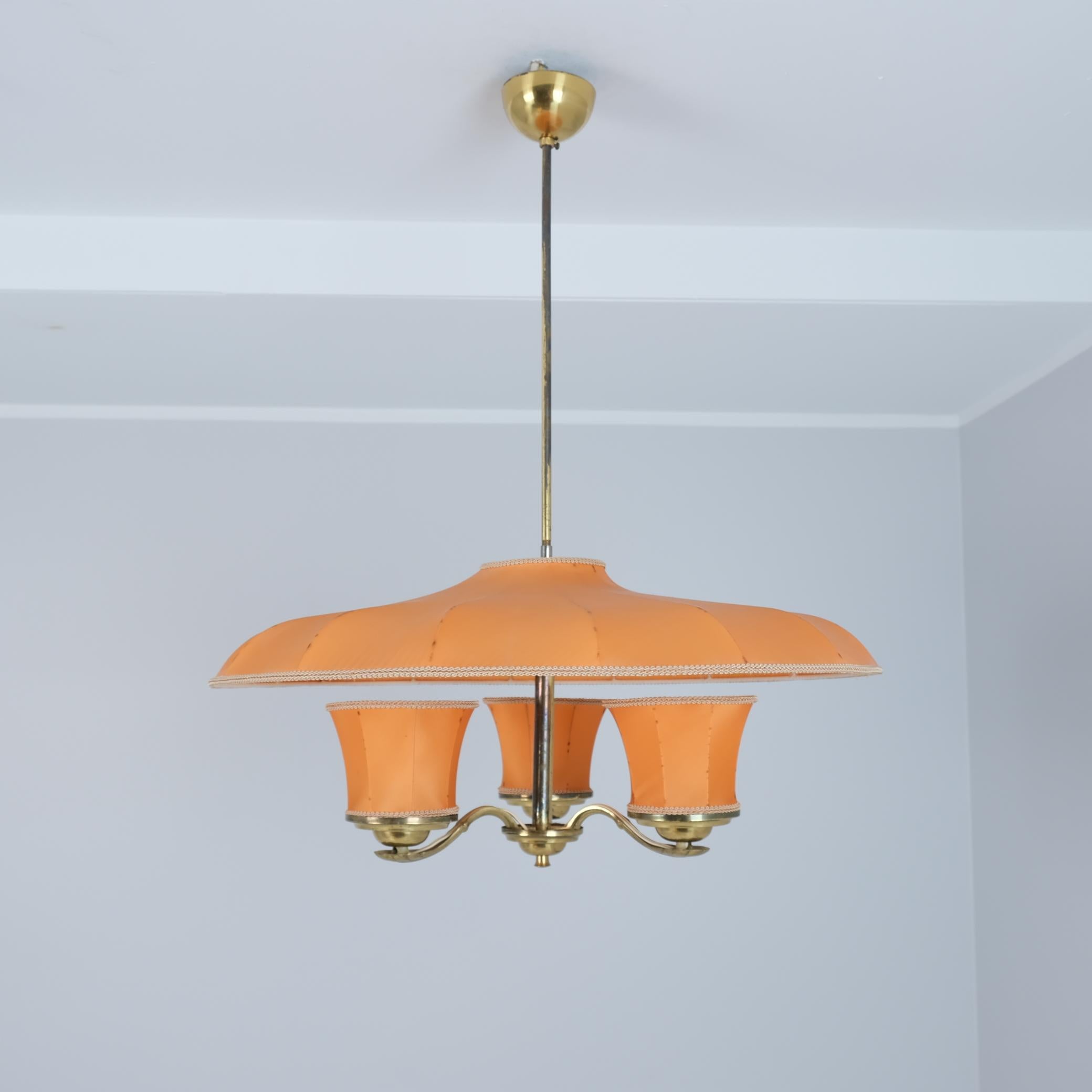 Una splendida e rarissima lampada da soffitto finlandese di metà secolo di Itsu, uno dei principali produttori di illuminazione della Finlandia. La lampada è in condizioni assolutamente originali con paralumi in tessuto originali. La lampada