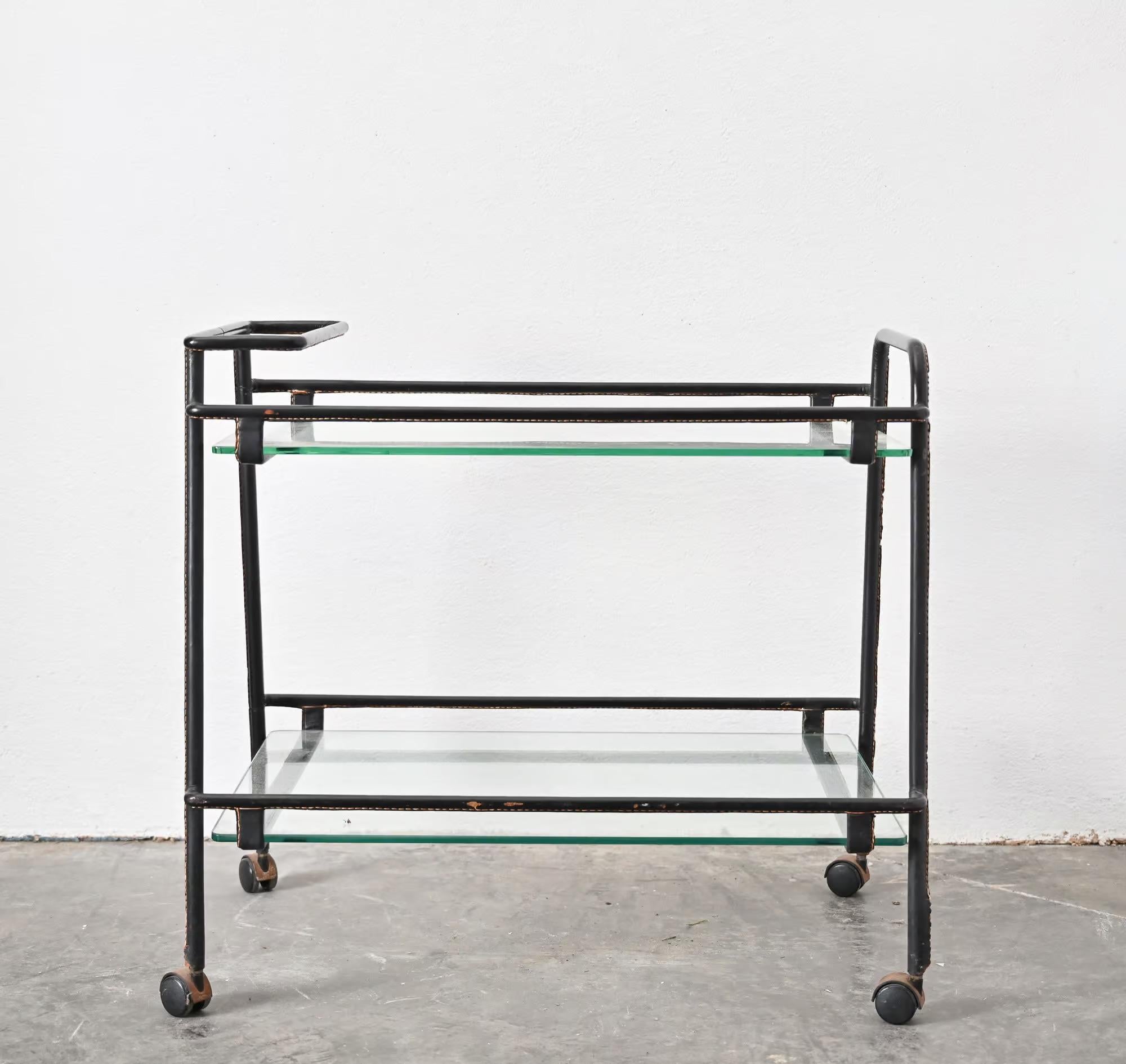 Mid century bar cart attributed to Jacques Adnet – Steel frame clad in saddle stitched black leather. A classic Adnet design with it’s original glass shelves.

France circa 1960

Jacques Adnet was a prominent French designer and architect known for