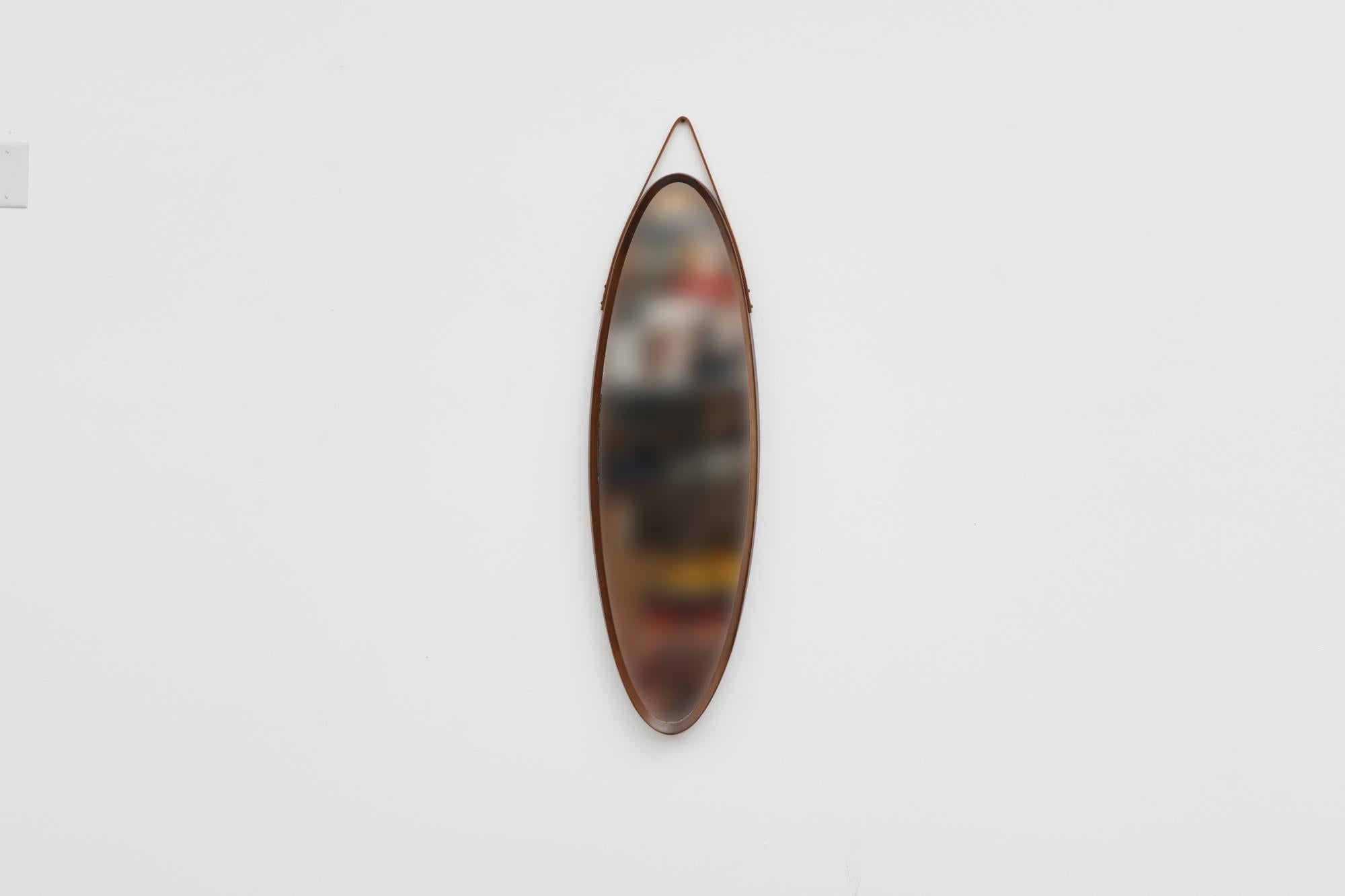 Gorgeous Mid-Century Jacques Adnet style teak oval wall mounted mirror with leather strap. Beautiful bent teak frame in original condition with wear consistent with age and use. Other similar mirrors are available and listed separately