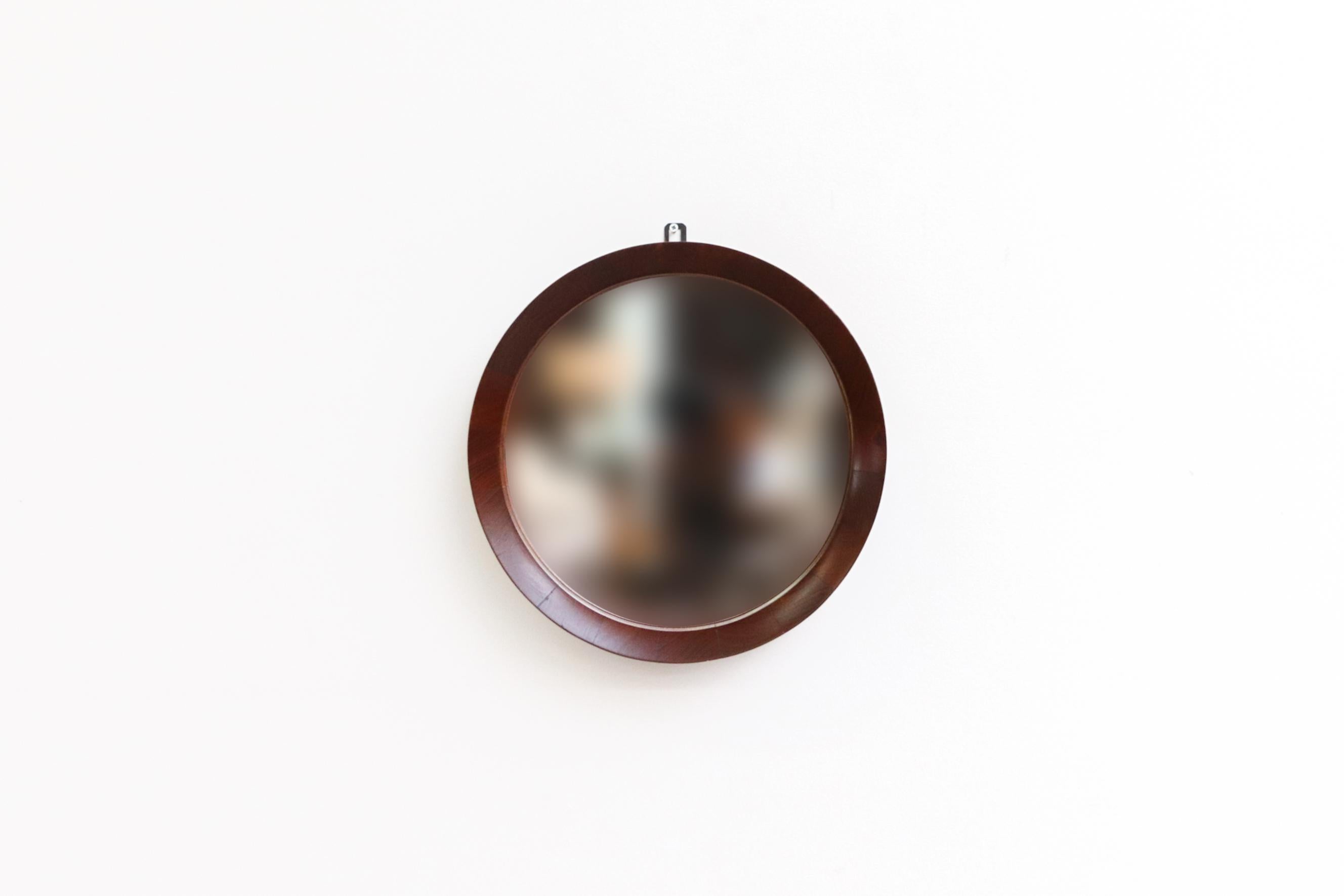 Lovely, Mid-Century, Jacques Adnet inspired round teak wall mirror. Expertly carved teak wood frame with original glass and attached wall mount. In original condition with some light wear consistent with age and use.  