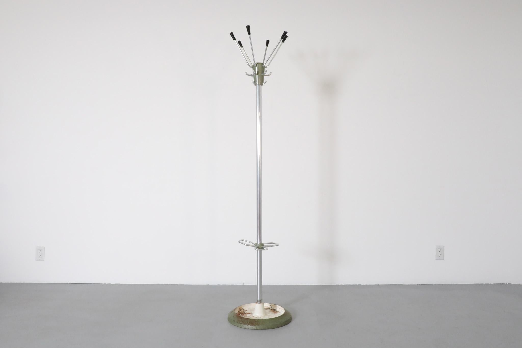 Mid-Century, Jacques Adnet inspired five-armed Deco standing coat rack with chrome trunk, green enameled metal accents and curved hook umbrella holders on green and white enameled weighted base . An attractive and functional home accent in original