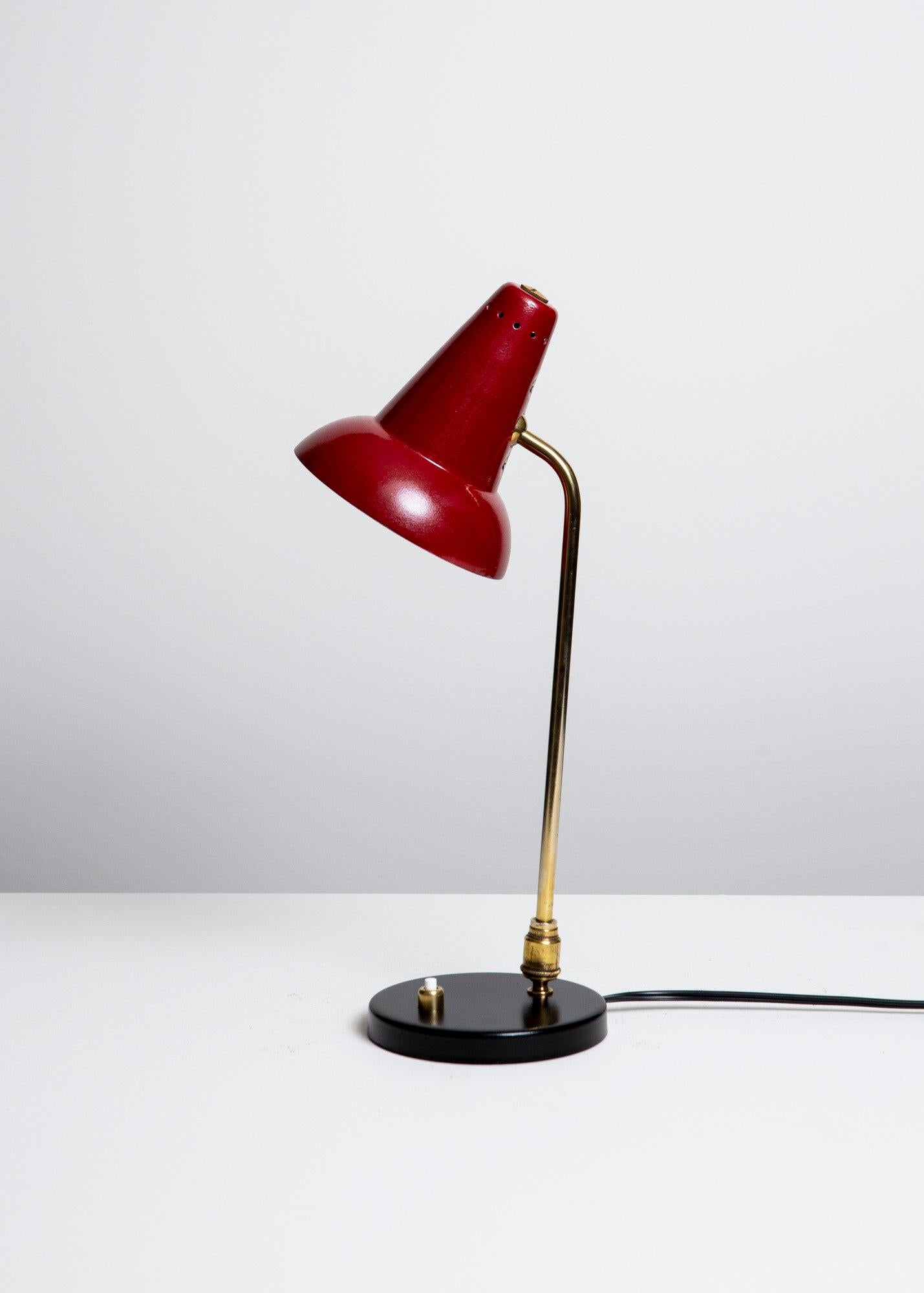 Jacques Biny  Lámpara de mesa fabricada en la década de 1950.  Pantalla de aluminio perforado rojo sangre, vástago y pivote de latón, pie de acero esmaltado.  Se recomiendan bombillas incandescentes candelabro G-16,5 de 60 vatios como máximo o