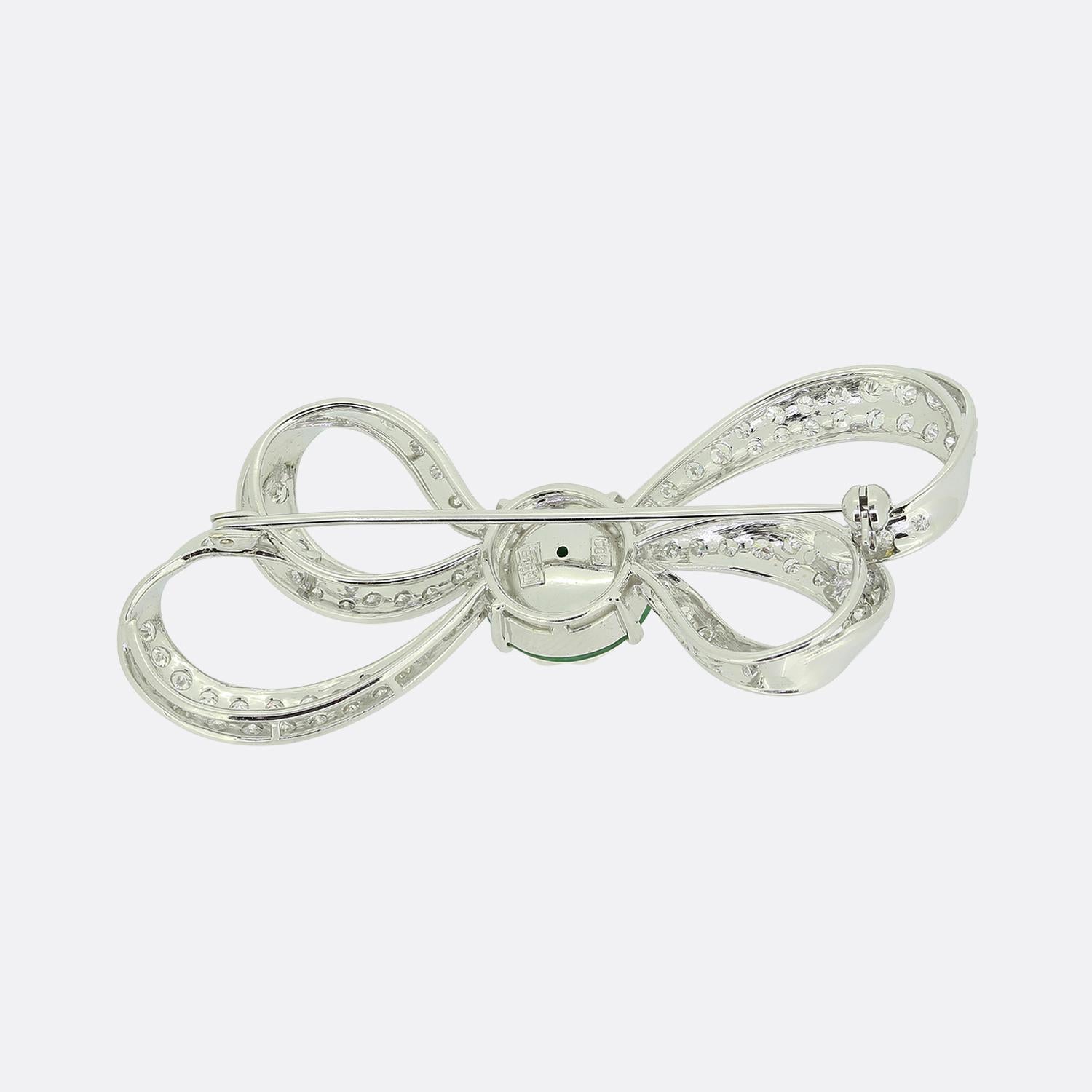 Here we have a lovely jade and diamond brooch crafted into the shape of a ribbon. A curvaceous double bowed design has been crafted from 14ct white gold and pavé set with an array of round brilliant cut diamonds with a round natural jade disc at the
