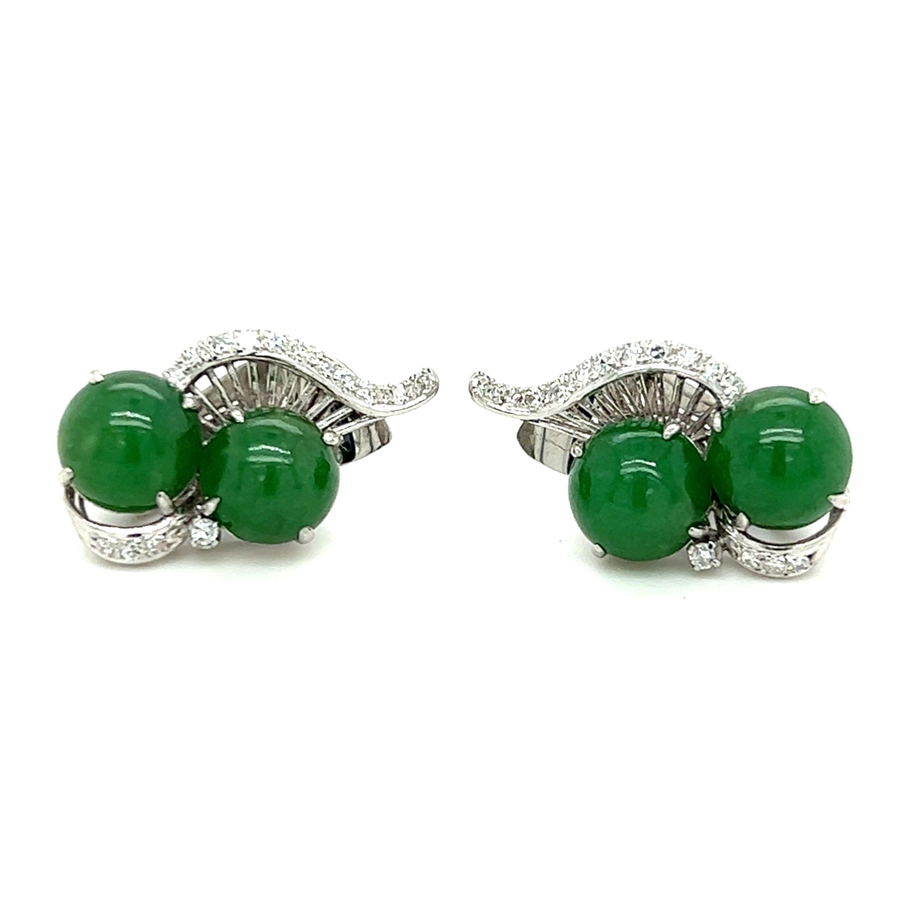 Chic and timeless, these 1950s jadeite and diamond platinum ear clips feature deep, saturated green jadeite set inside a winding spray of diamonds. These earrings offer color, sparkle, and glamour without being over-the-top, allowing them to be