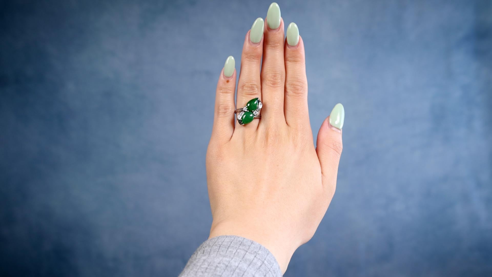 One Mid-Century Jadeite Diamond 14k White Gold Toi et Moi Ring. Featuring two pear cut jadeite cabochons with a total weight of approximately 4.20 carats. Accented by two round brilliant and four baguette cut diamonds with a total weight of